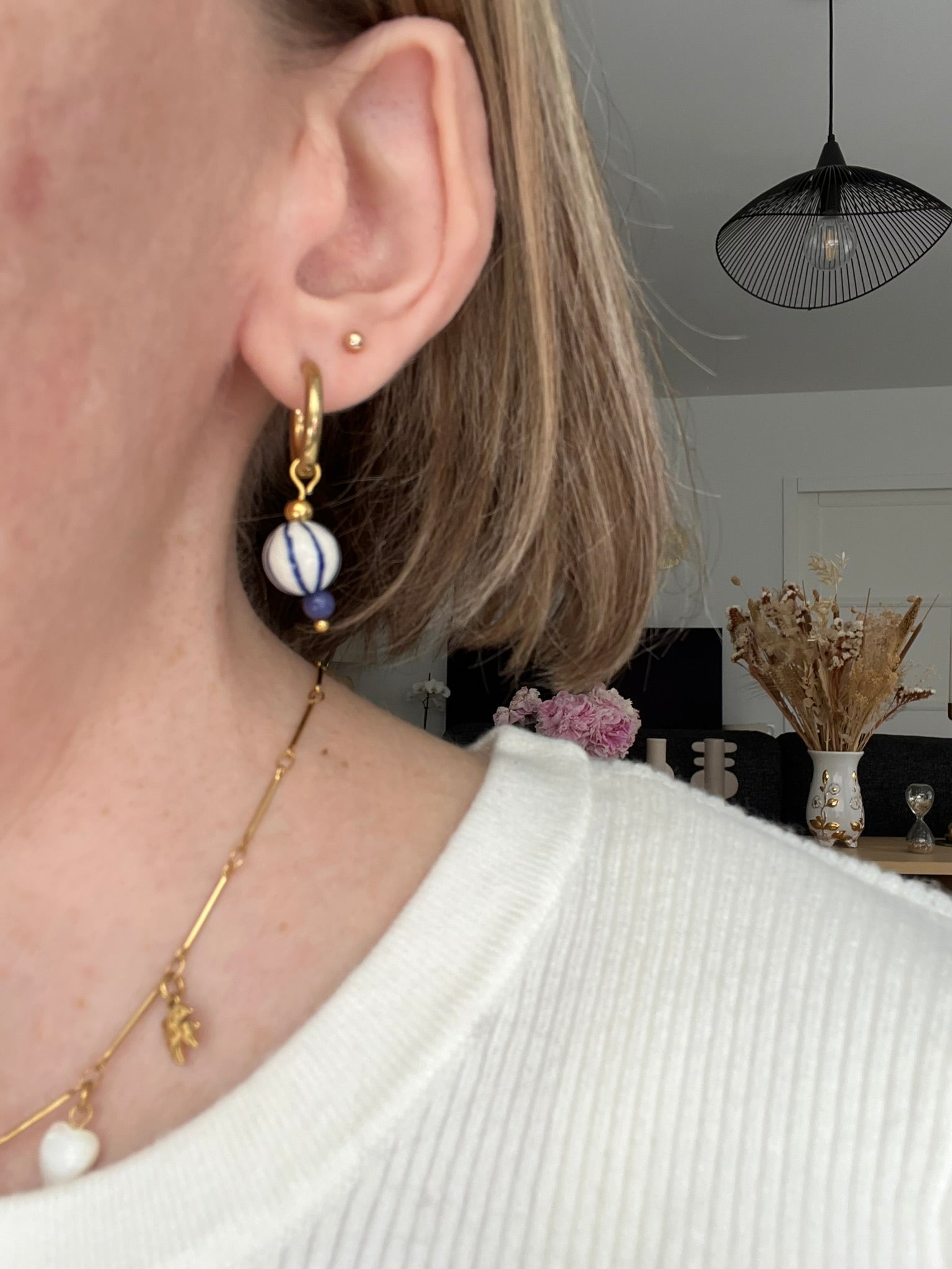 Boucles d'oreilles fantaisie fait main.
Créoles en acier inoxydable doré. Perle ronde en céramique blanche rayée bleu.
Bijou fait main