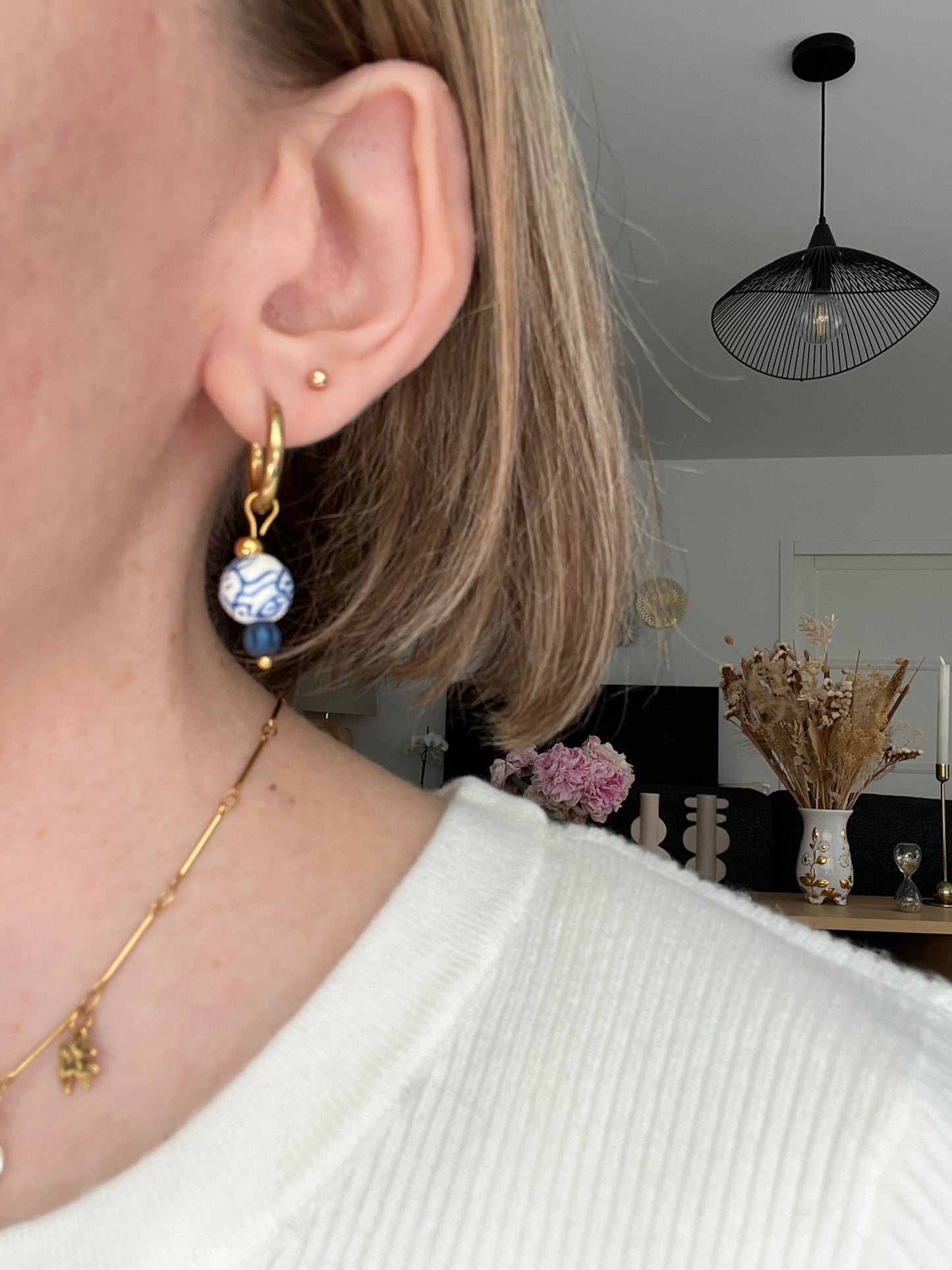 Boucles d'oreilles fantaisie fait main.
Créoles en acier inox doré. Perles rondes en céramique blanche, motif floral bleu.
Bijou fait main