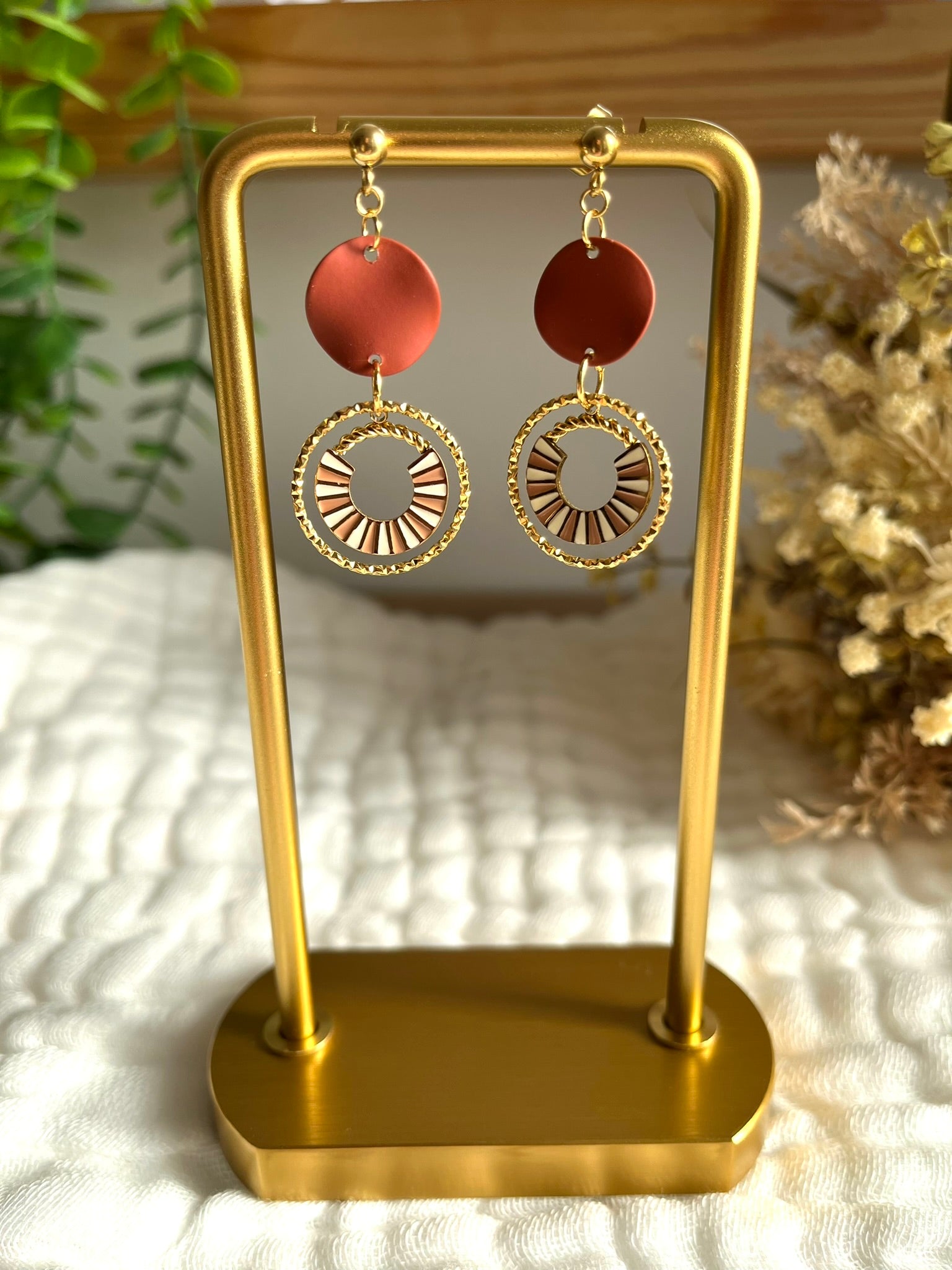 Boucles d'oreilles fantaisie fait main.
Clous d'oreilles en acier doré, sequin ondulé marron, pendentif design en acier doré et émail rose et blanc.
Bijou artisanal fait main.