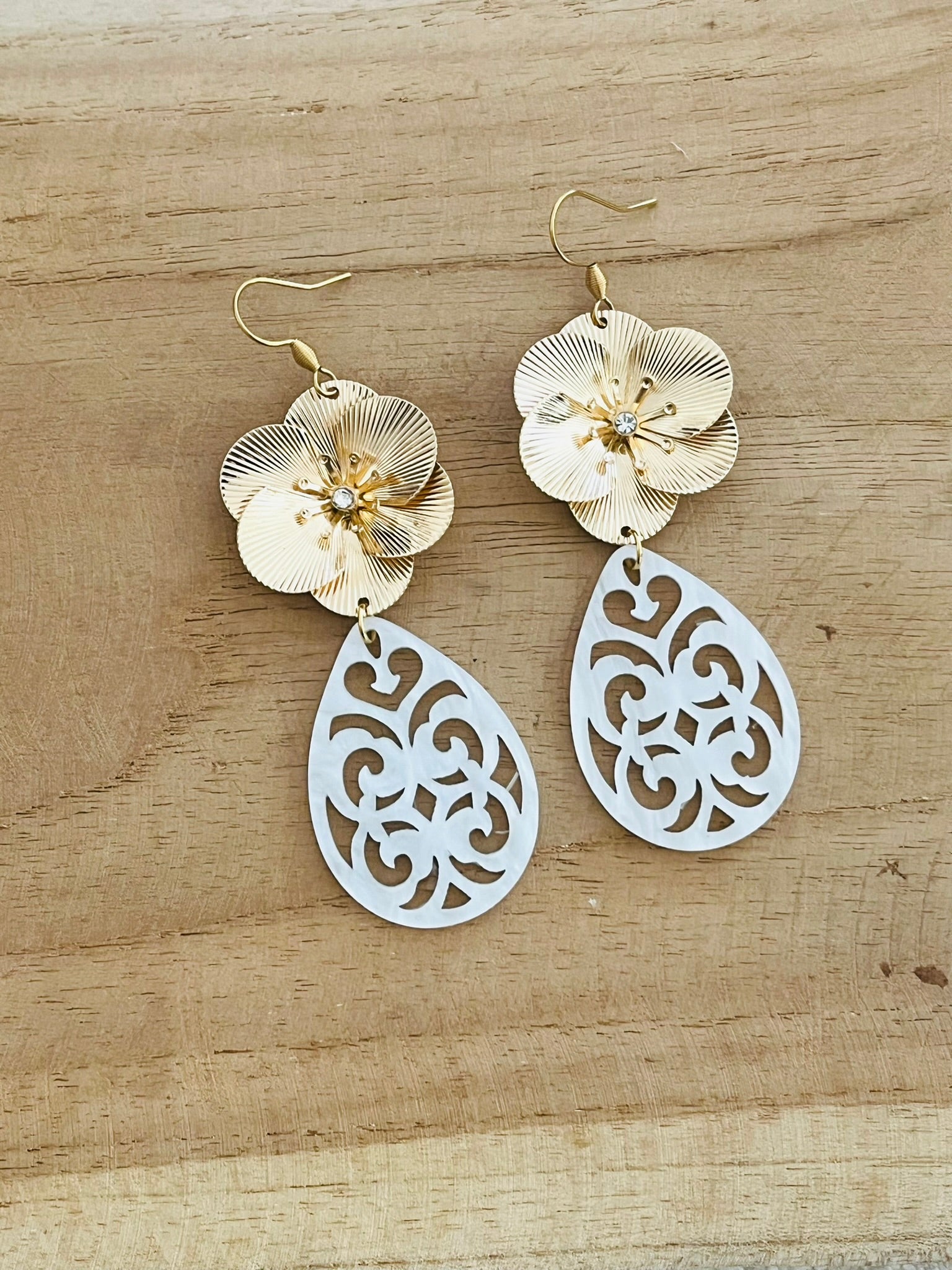 Boucles d'oreilles fantaisie pendantes style baroque. Grosse fleur dorée et pendentif goutte en acrylique blanc.
Bijou fantaisie fait main.