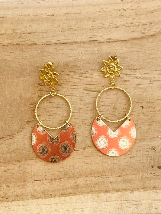 Boucles d'oreilles fantaisie pendantes en acier inoxydable doré.
Pendentifs arrondis orange terracotta, motifs soleils.
Bijou fantaisie fait main.