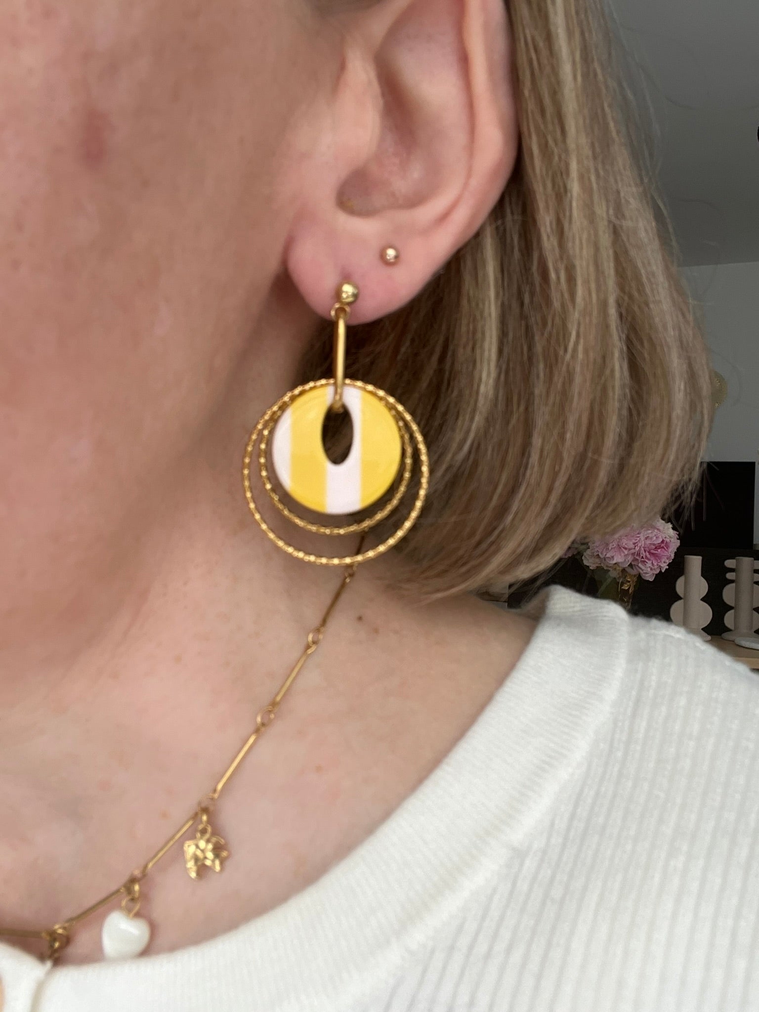 Boucles d'oreilles fantaisie fait main.
Clous d'oreilles en acier doré.
Jeu d'anneaux ciselés de 25 et 30mm en acier doré.
Pendentifs ronds en acrylique rayés jaune et blanc.
Bijou fantaisie fait main.