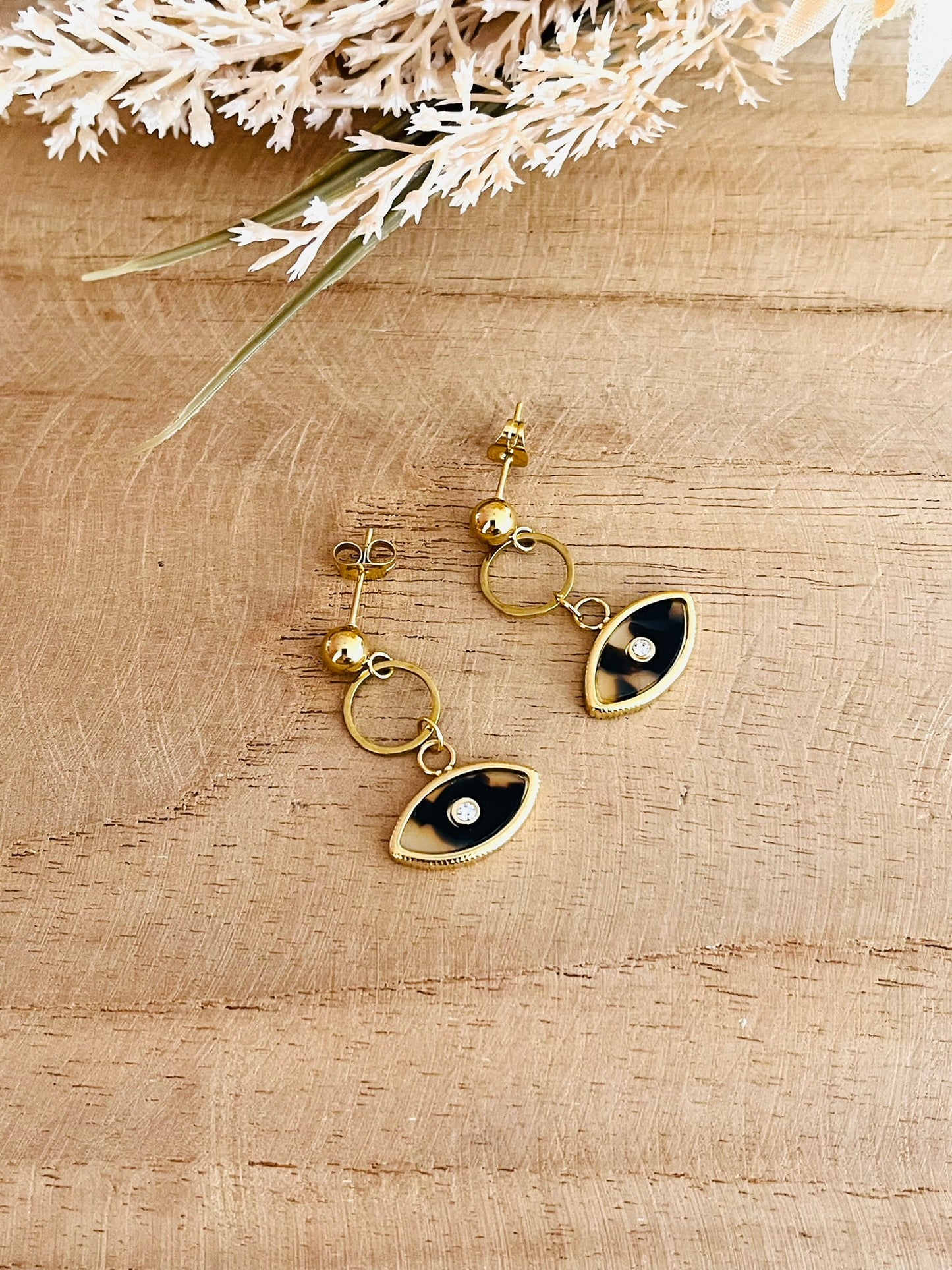Boucles d'oreilles fantaisie fait main.
Clous d'oreilles en acier inoxydable doré, pendentif oeil beige.
Bijou fantaisie fait main.