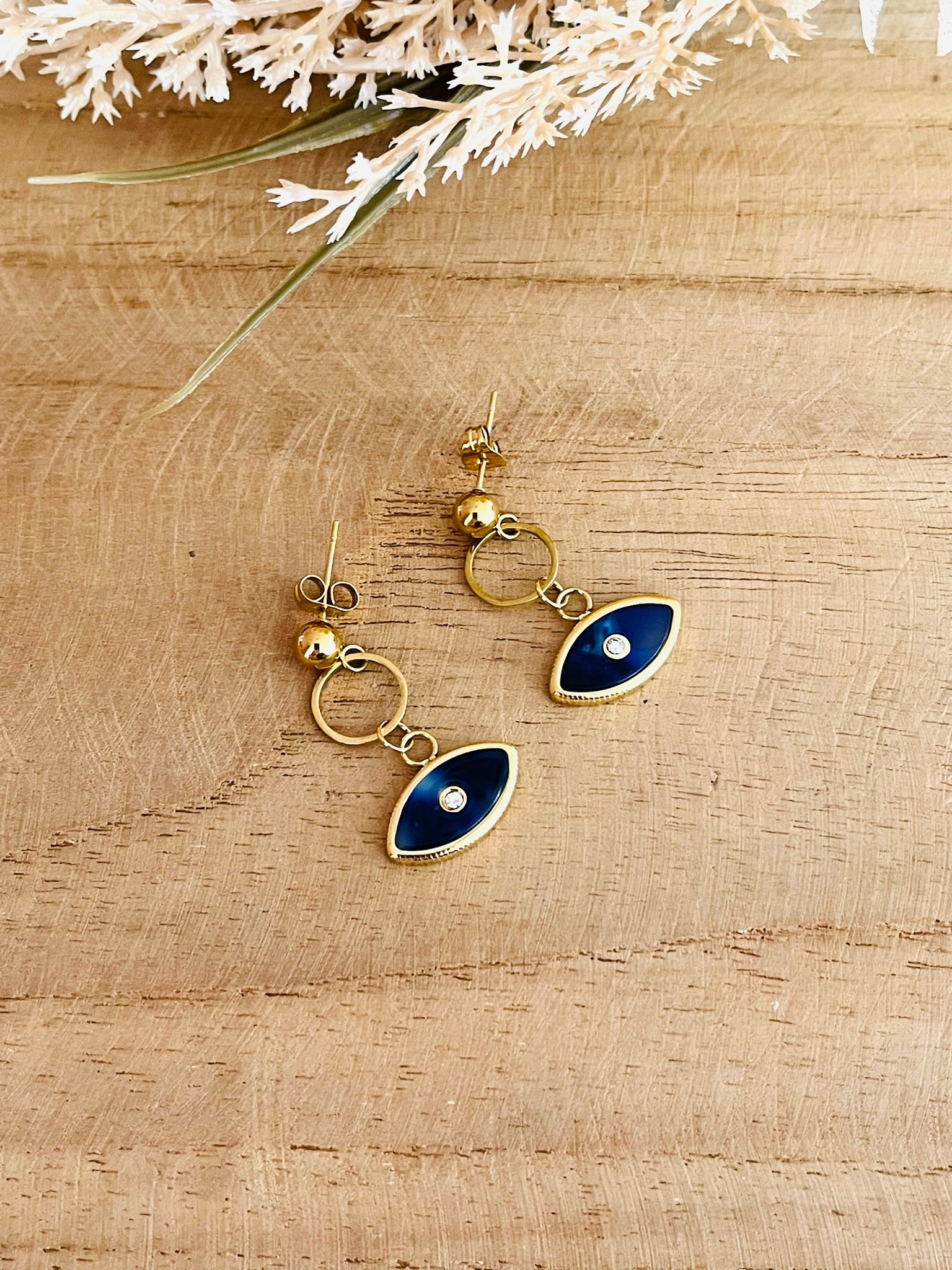 Boucles d'oreilles fantaisie fait main.
Clous d'oreilles en acier inoxydable doré, pendentif oeil bleu foncé.
Bijou fantaisie fait main.
