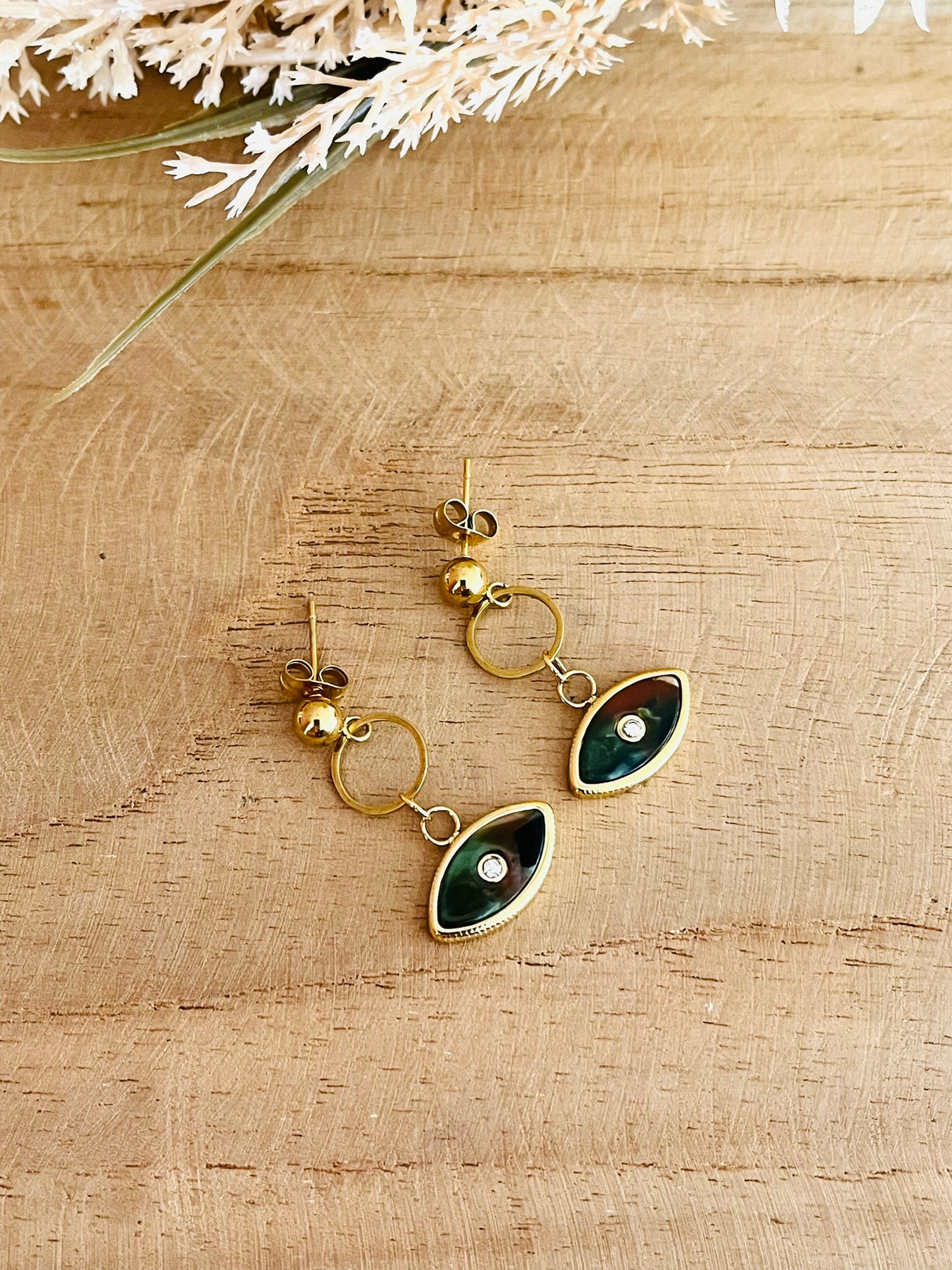 Boucles d'oreilles fantaisie fait main.
Clous d'oreilles en acier inoxydable doré, pendentif oeil vert kaki.
Bijou fantaisie fait main.