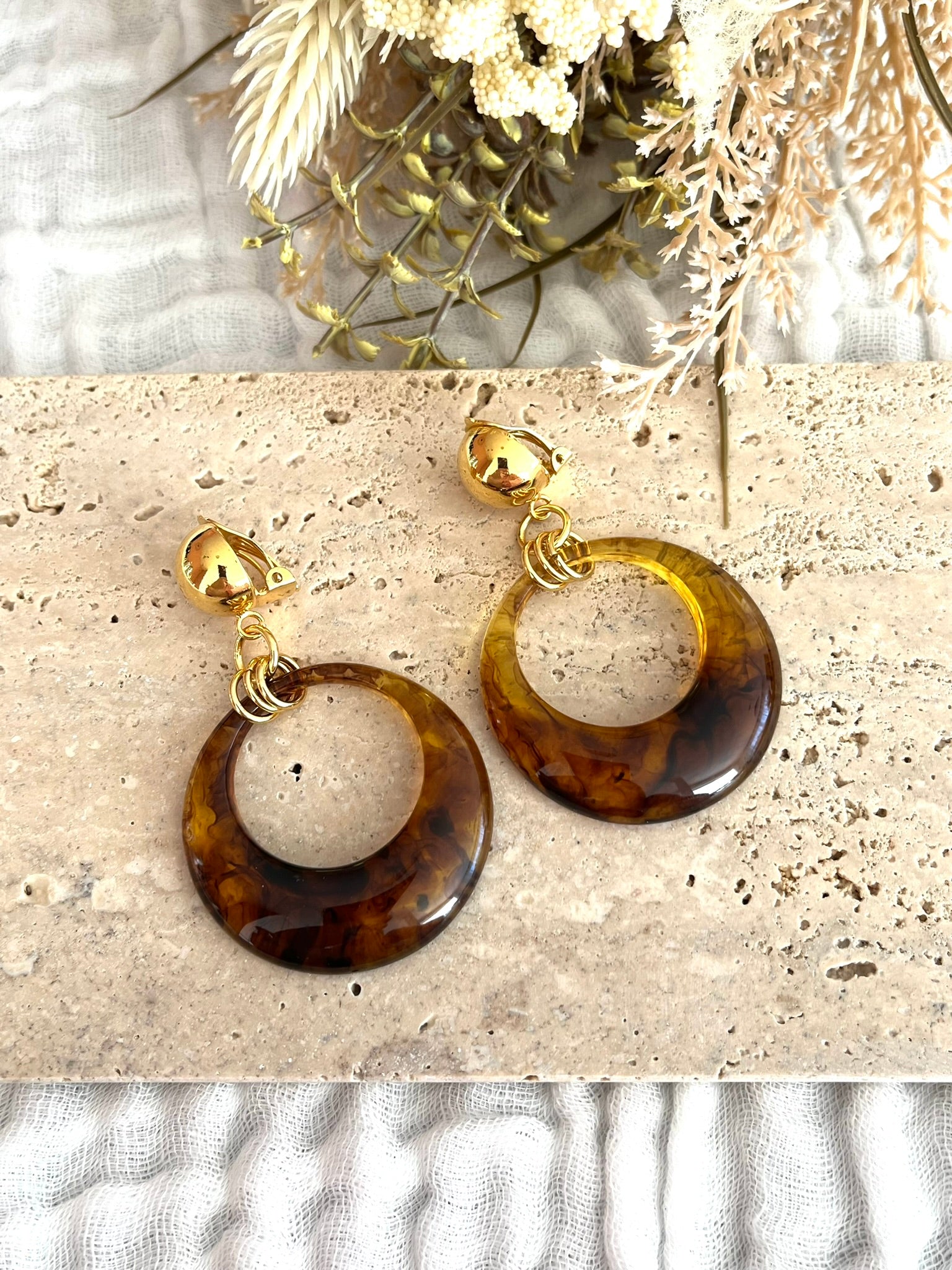 Boucles d'oreilles à clip fantaisie fait main.
Clips d'oreilles boule en laiton doré à l'or fin.
Pendentif en résine rond de couleur ambre.
Bijou fantaisie fait main.