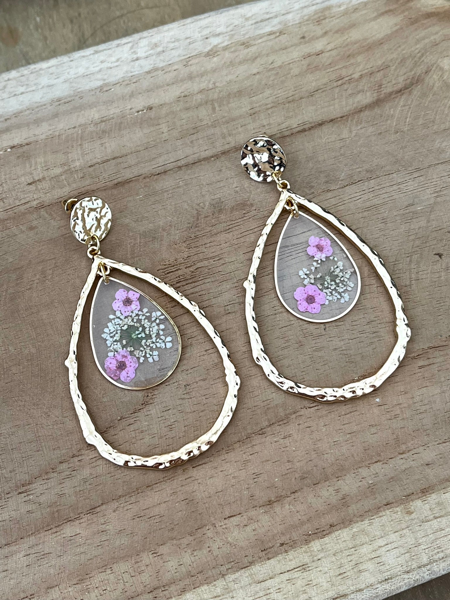 Clous d'oreilles ronds martelés dorés, grands pendentifs goutte doré, pendentifs goutte en résine avec fleurs séchées rose.
Bijou fantaisie fait main.