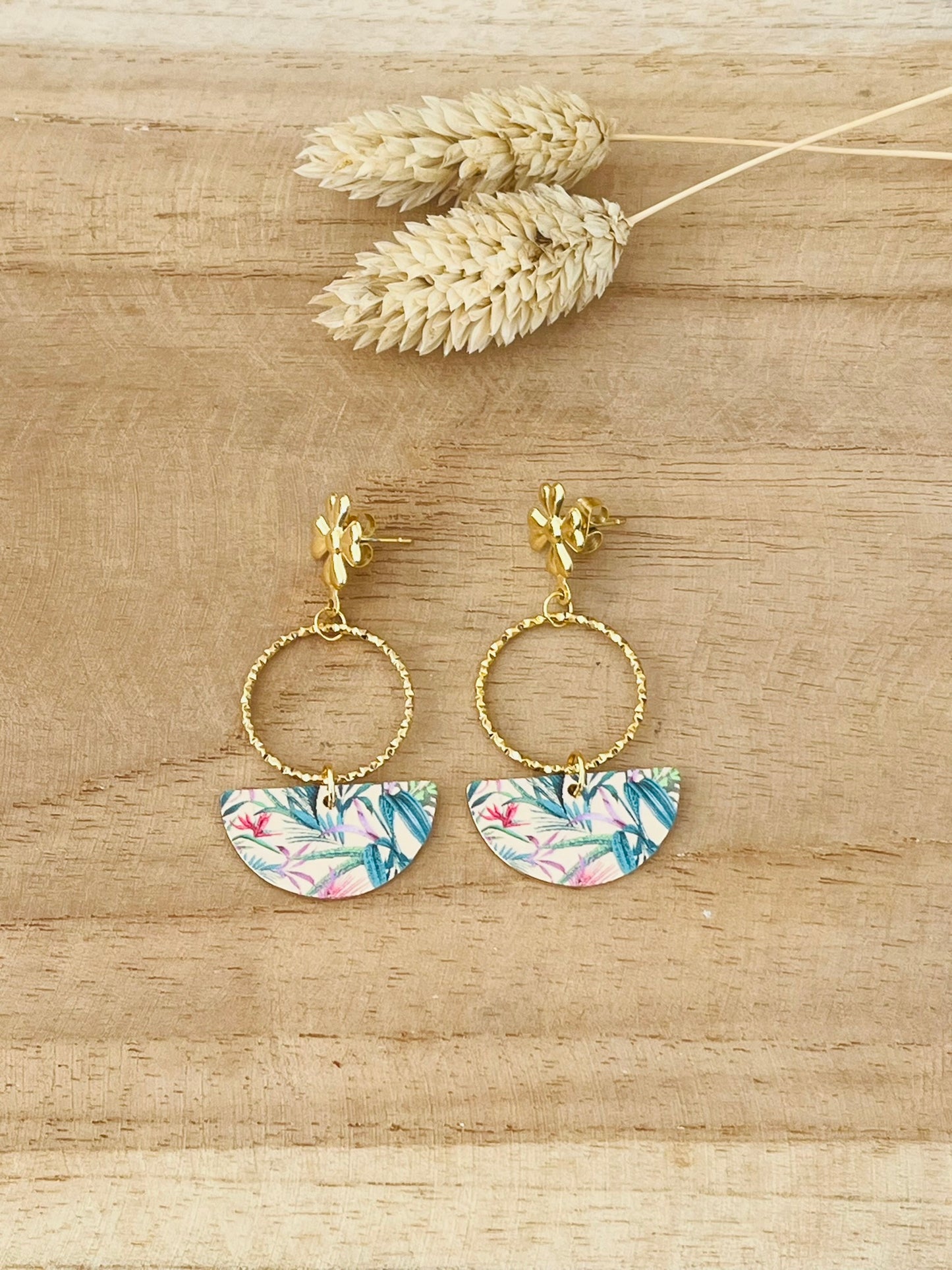 Boucles d'oreilles fantaisie faites main.
Clous d'oreilles fleur en acier inoxydable doré.
Anneaux fermés ciselés en acier inox.
Pendentifs demi-lune dorés et imprimé de feuilles tropicales rose et vert.
Bijou fantaisie fait main