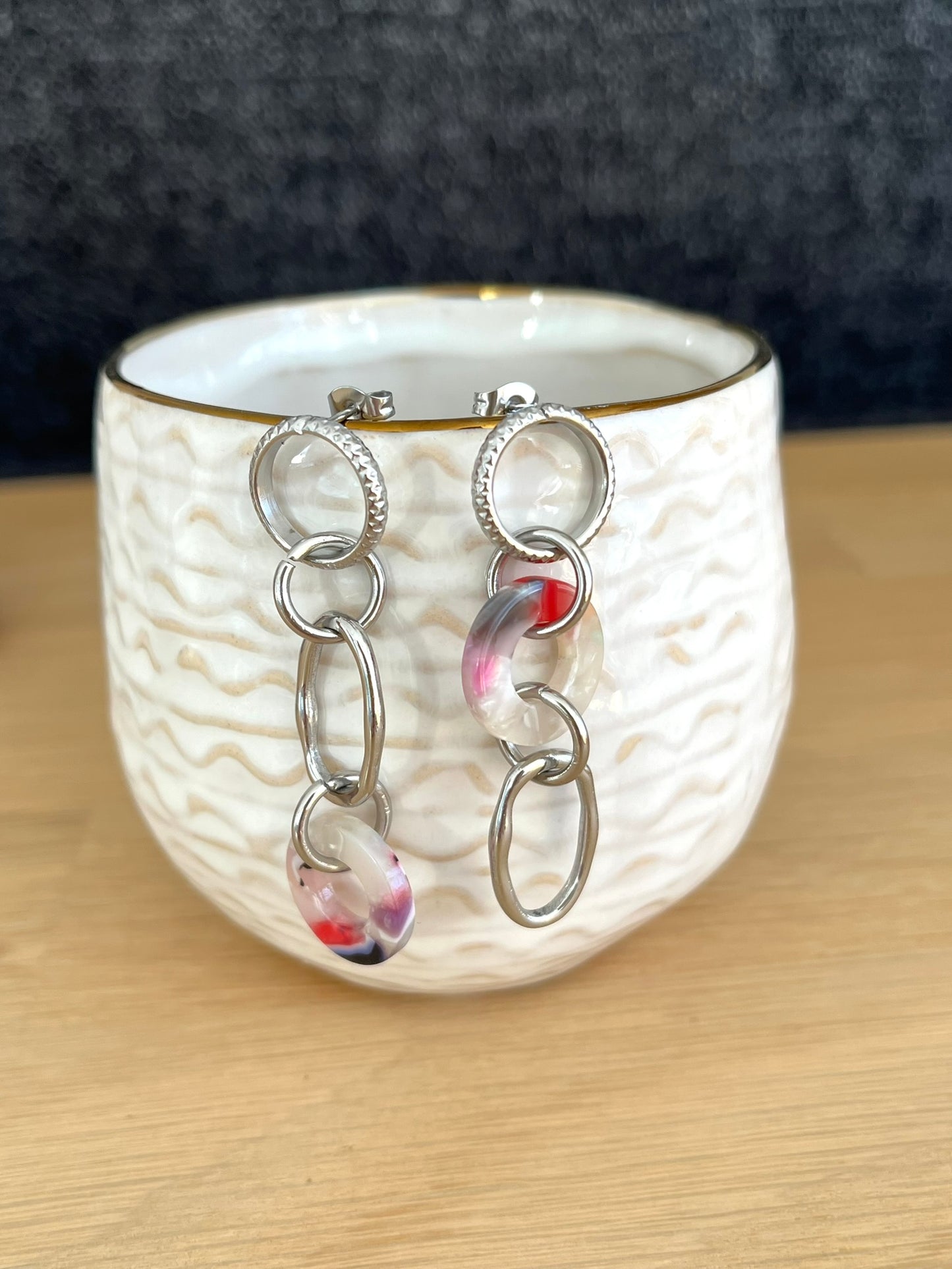 Boucles d'oreilles fantaisie faites main.
Boucles d'oreilles asymétriques en acier inoxydable couleur argent. Pendentifs ronds donuts en acrylique blanc-violet.
Bijou fantaisie fait main.