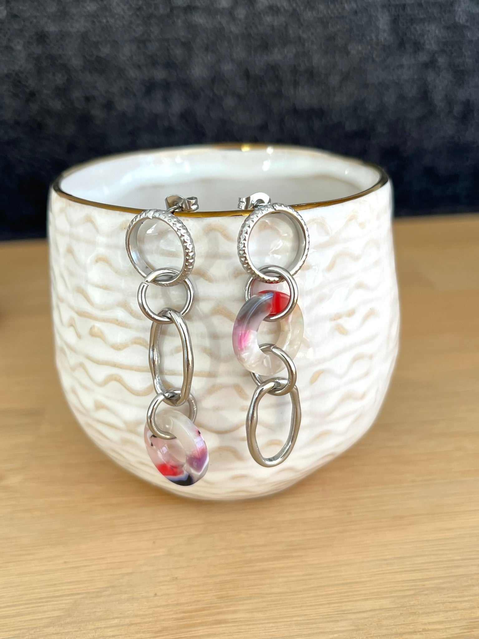 Boucles d'oreilles fantaisie faites main.
Boucles d'oreilles asymétriques en acier inoxydable couleur argent. Pendentifs ronds donuts en acrylique blanc-violet.
Bijou fantaisie fait main.