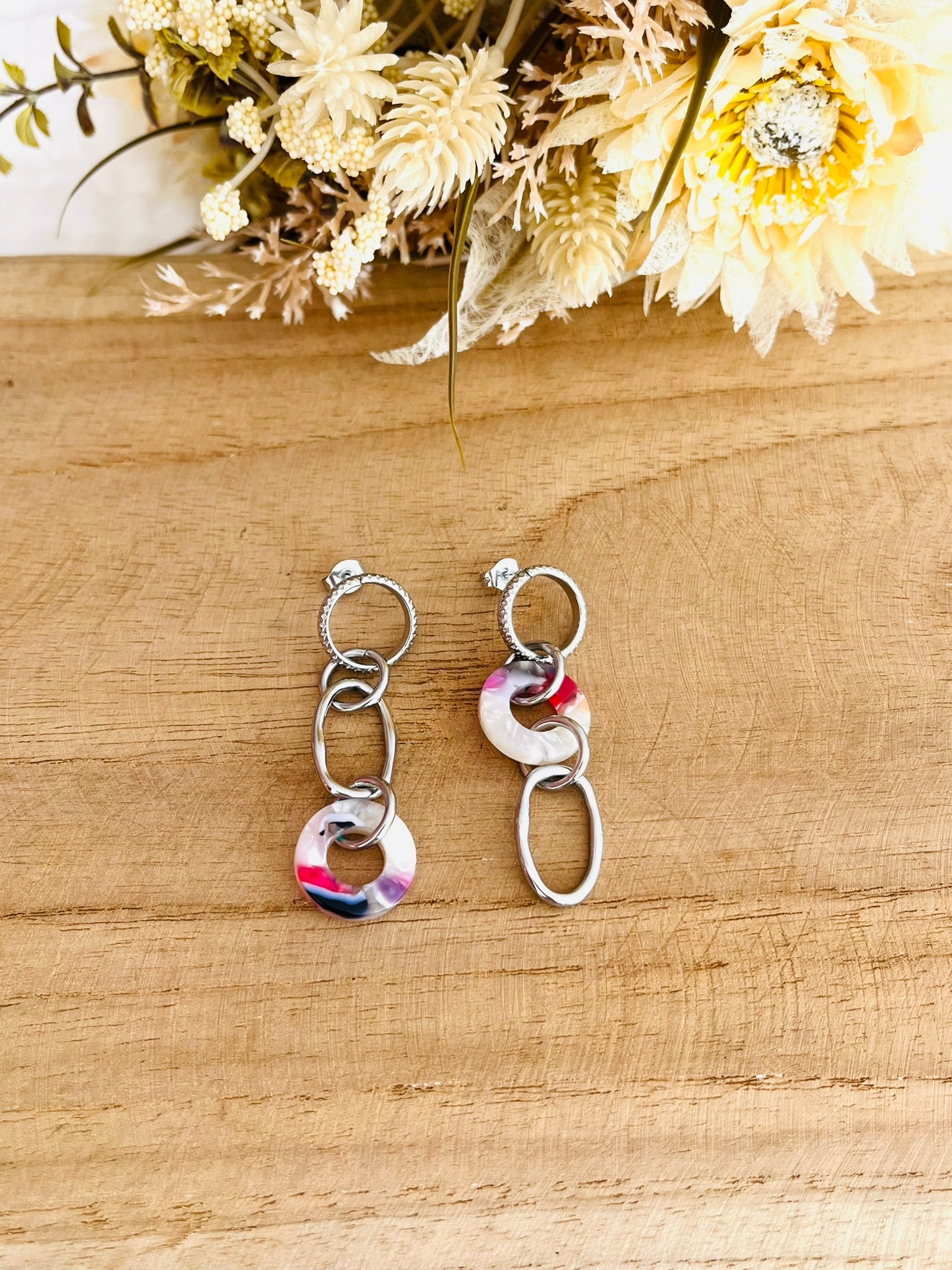 Boucles d'oreilles fantaisie faites main.
Boucles d'oreilles asymétriques en acier inoxydable couleur argent. Pendentifs ronds donuts en acrylique blanc-violet.
Bijou fantaisie fait main.