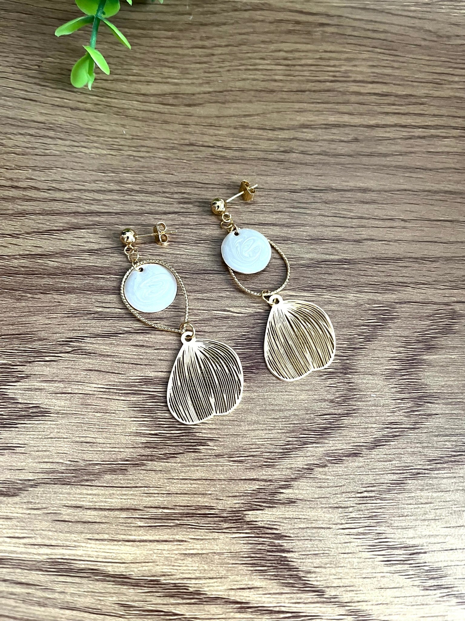 Boucles d'oreilles fantaisie fait main.
Clous d'oreilles doré, gouttes ciselées et estampes feuille en laiton doré à l'or fin 18k. Sequins ronds blanc nacré.
Bijou fantaisie fait main.