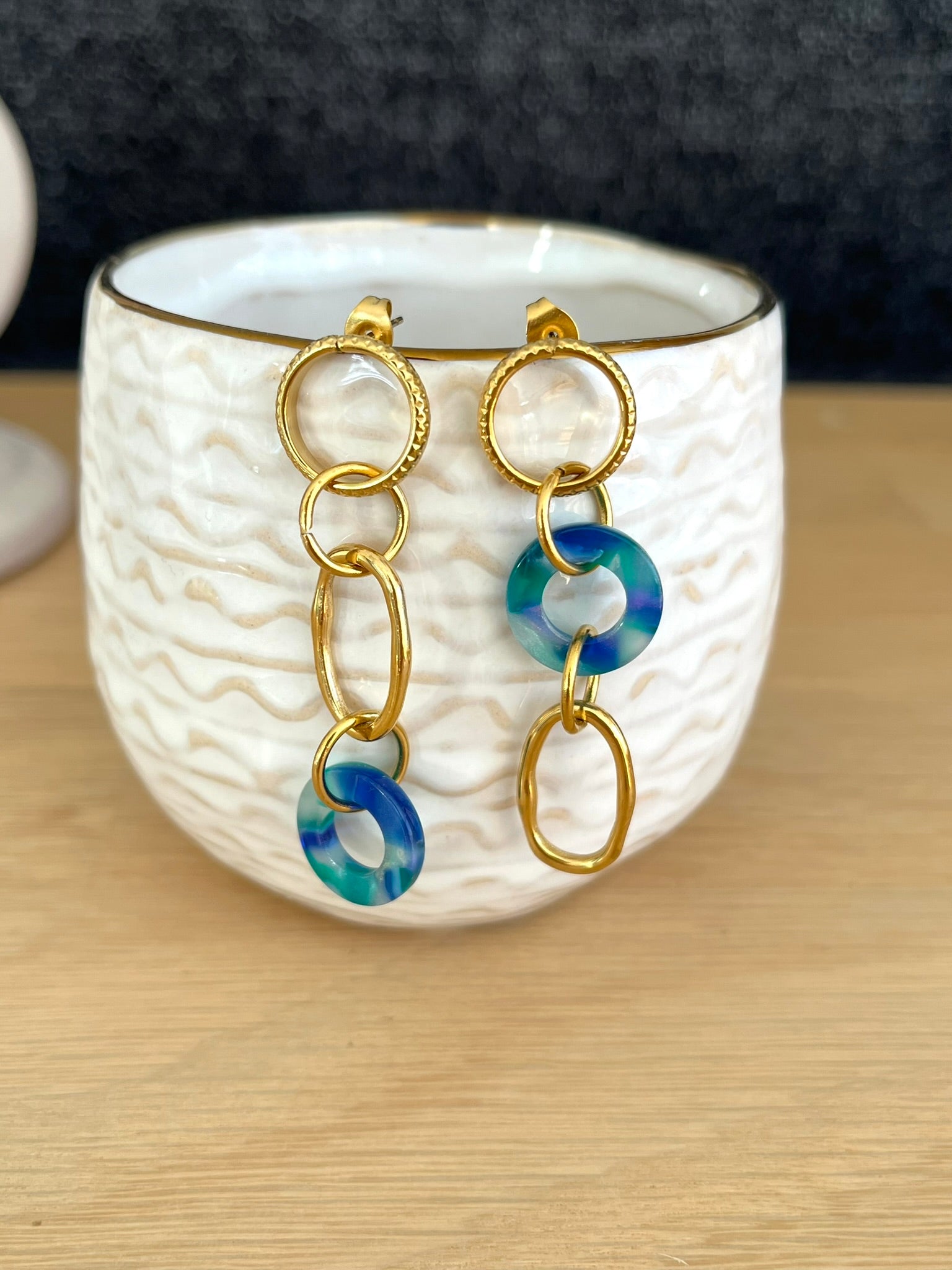 Boucles d'oreilles fantaisie faites main.
Boucles d'oreilles asymétriques en acier inoxydable doré. Pendentifs ronds donuts en acrylique bleu-vert.
Bijou fantaisie fait main.