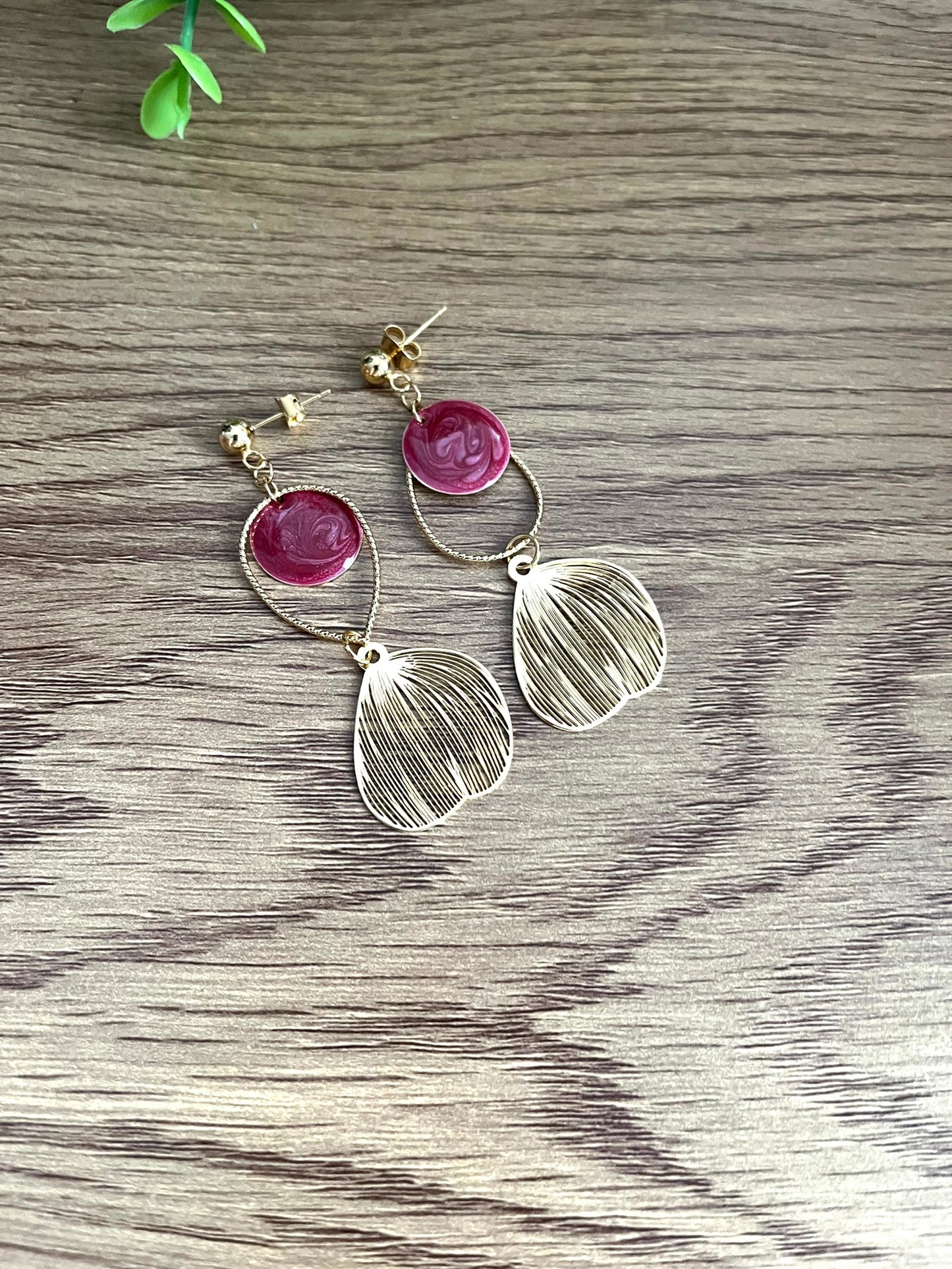 Boucles d'oreilles fantaisie fait main.
Clous d'oreilles doré, gouttes ciselées et estampes feuille en laiton doré à l'or fin 18k. Sequins ronds bordeaux nacré.
Bijou fantaisie fait main.
