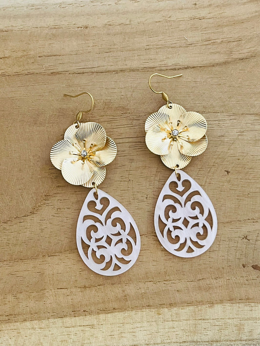 Boucles d'oreilles fantaisie pendantes style baroque. Grosse fleur dorée et pendentif goutte ajourée en acrylique rose pâle.
Bijou fantaisie fait main.