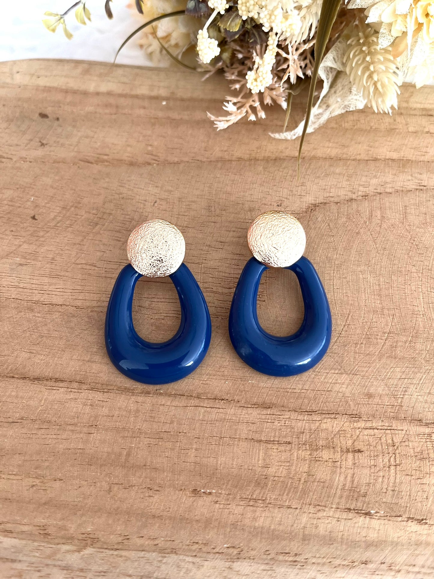 Boucles d'oreilles fantaisie fait main.
Boucles d'oreilles à clous ronds en laiton doré.
Pendants de forme arrondie en résine bleu foncé.
Style bohème chic, rétro.
Bijou fantaisie fait main.