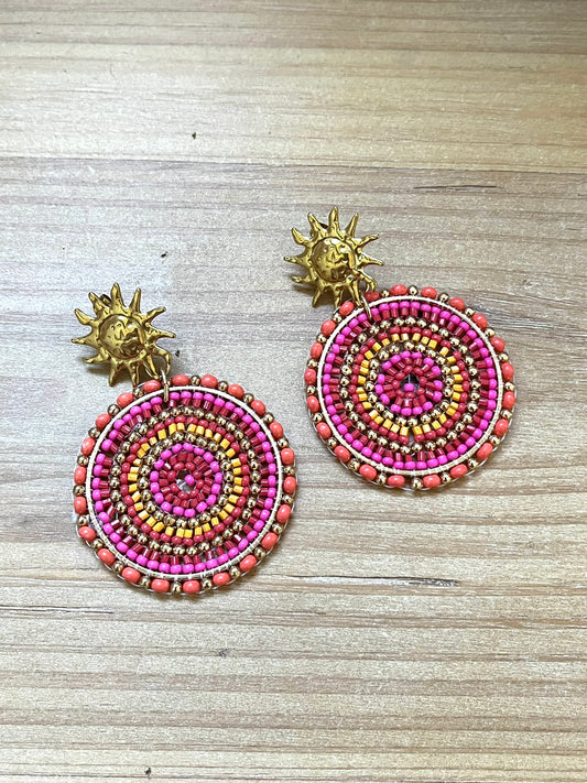 Boucles d'oreilles fantaisie fait main.
Clous d'oreilles soleil en acier doré.
Pendentif rond en perles de rocaille rose, orange.
Bijou fait main.