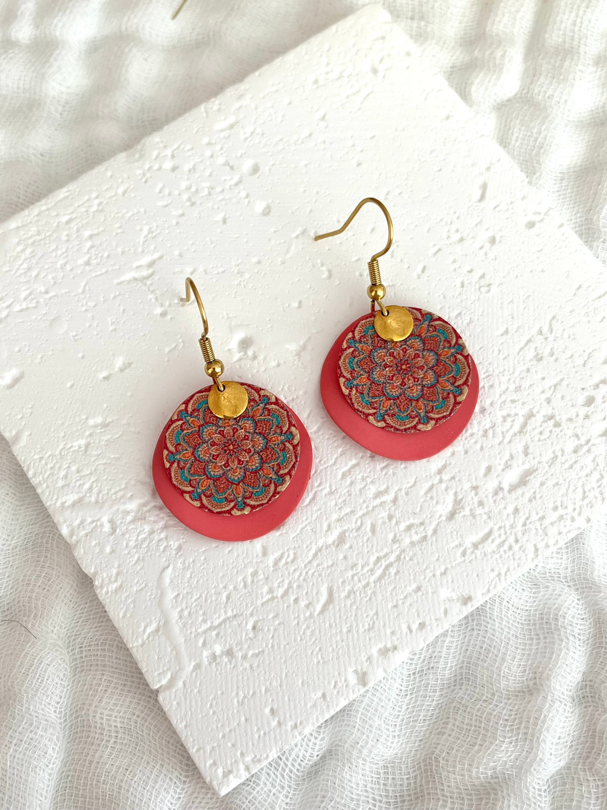 Boucles d'oreilles fantaisie fait main.
Crochets d'oreilles en acier inox doré; sequins ronds ondulés rose, sequin rond motif mandala bleu, rose, orange; pampille ronde froissée doré.
Bijou fait main.