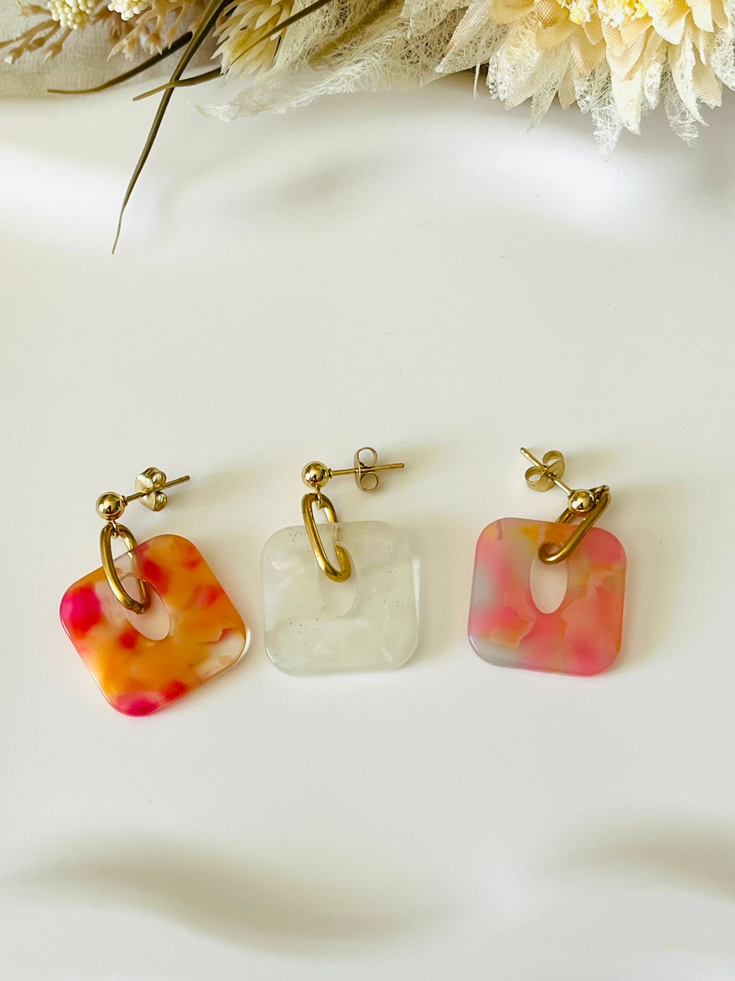Boucles d'oreilles fantaisie fait main.
Clous d'oreilles en acier doré. Pendentif carré en acrylique marbré.
Bijou fait main.