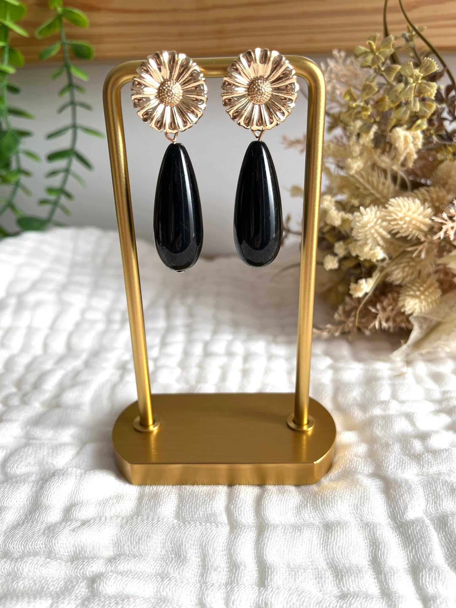 Boucles d'oreilles fantaisie fait main.
Clous d'oreilles fleur en laiton doré.
Perles goutte en résine noir.
Bijou artisanal fait main.