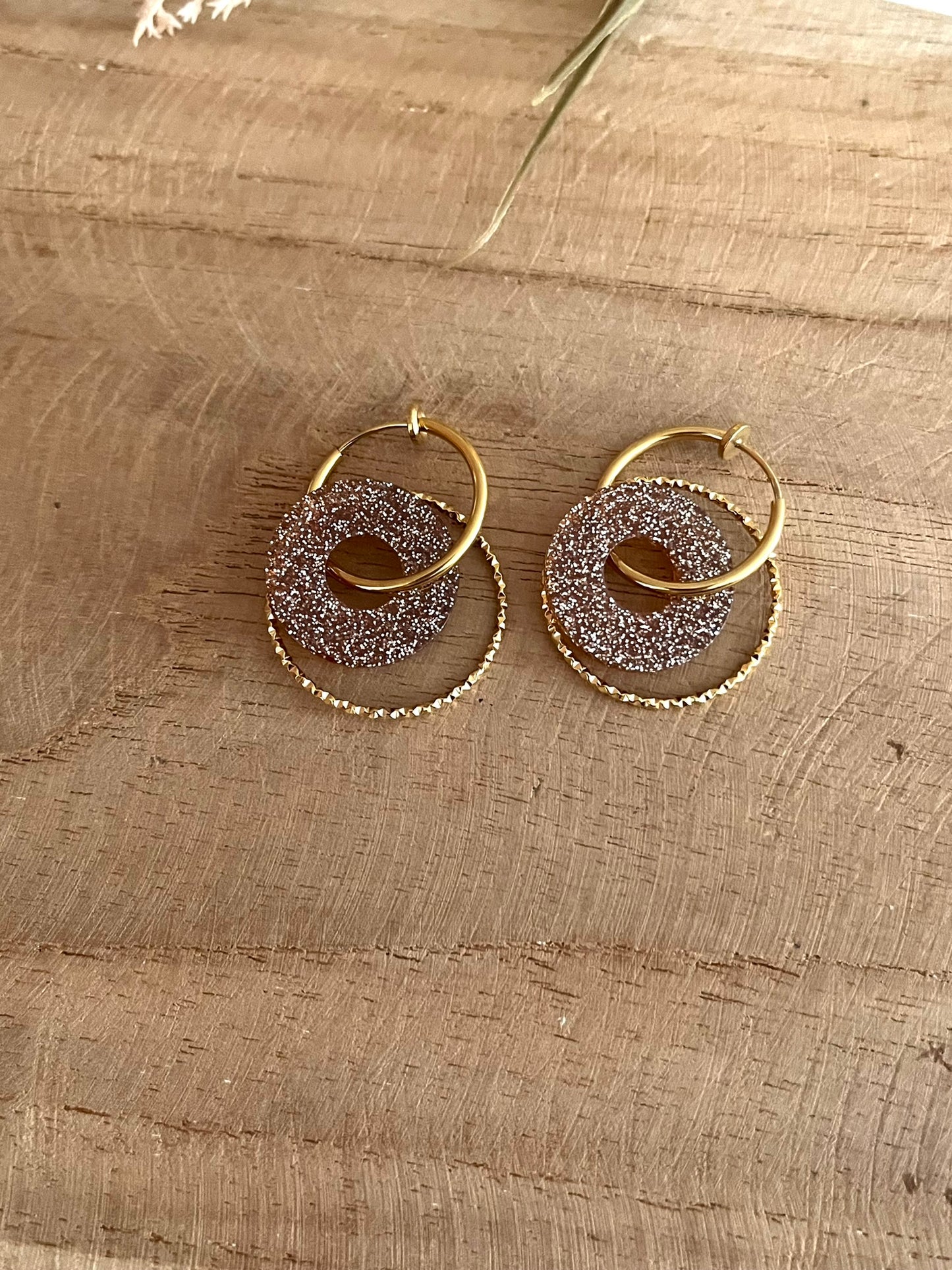 Boucles d'oreilles créoles en acier inoxydable doré pour oreilles non percées.
Pendentif donut en acrylique bronze pailleté.
Bijou fantaisie fait main.