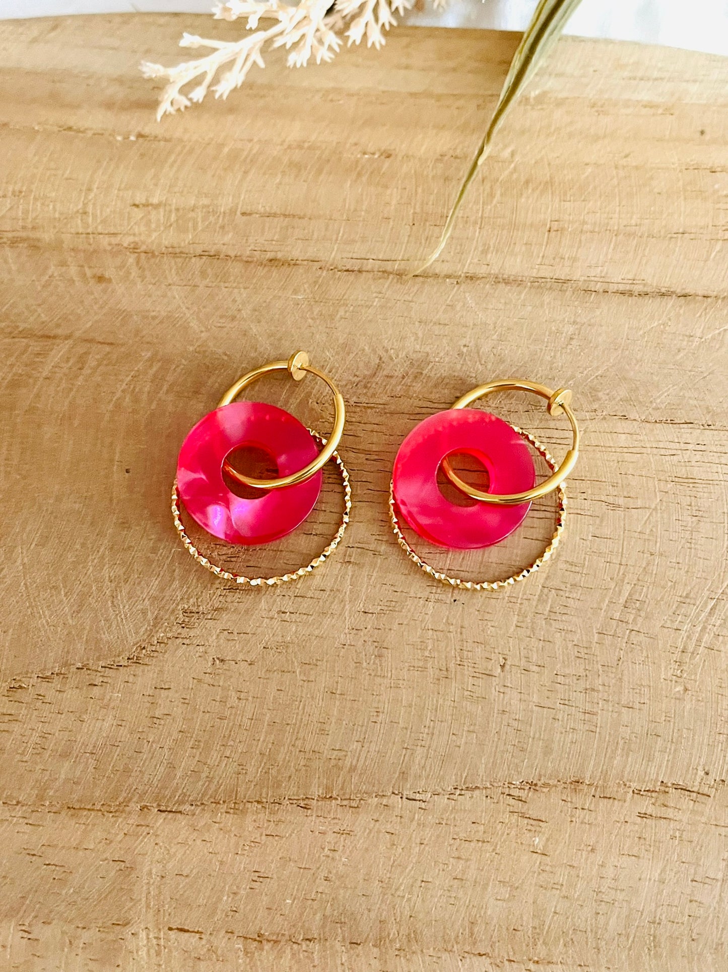 Boucles d'oreilles créoles en acier inoxydable doré pour oreilles non percées.
Pendentif donut en acrylique rose nacré.
Bijou fantaisie fait main.