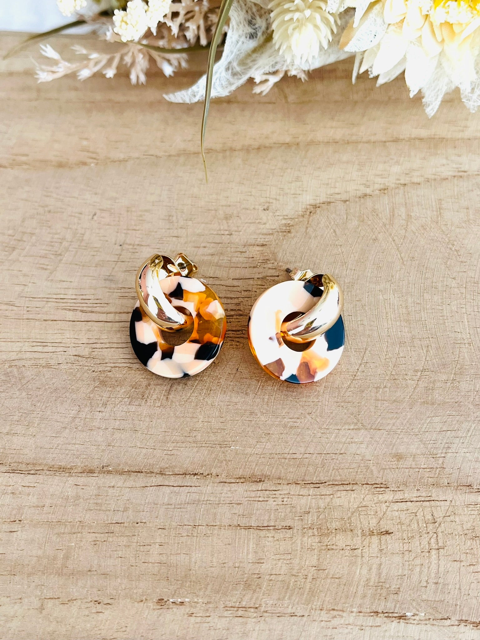 Boucles d'oreilles à clous style créoles bombées dorées.
Pendentifs donut en acrylique.
Boucles d'oreilles fantaisie fait main.