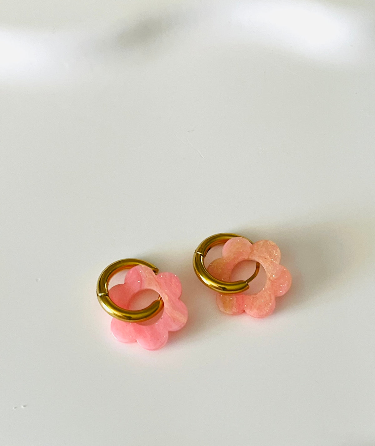 Boucles d'oreilles créoles adaptées pour les enfants à partir de 6 ans.
Créoles en acier inoxydable doré de 15mm.
Petites fleurs rose marbré avec paillettes en acrylique.
