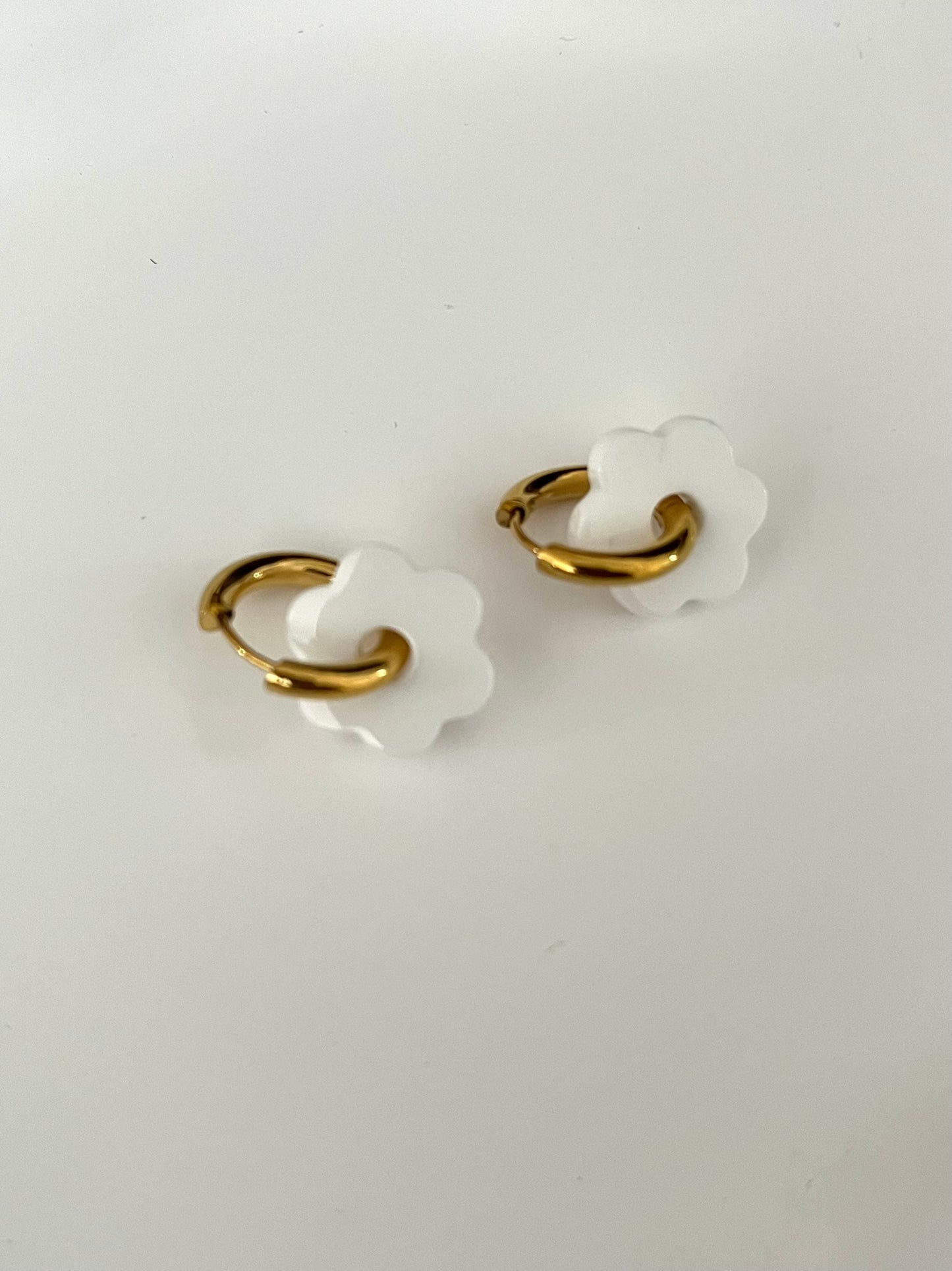 Boucles d'oreilles créoles adaptées pour les enfants à partir de 6 ans.
Créoles en acier inoxydable doré de 15mm.
Petites fleurs blanches en acrylique.
