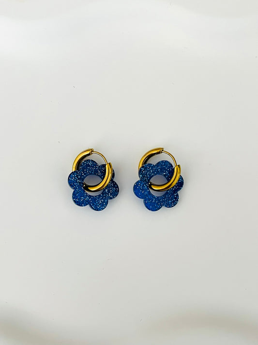 Boucles d'oreilles créoles adaptées pour les enfants à partir de 6 ans.
Créoles en acier inoxydable doré de 15mm.
Petites fleurs bleu pailleté en acrylique.

