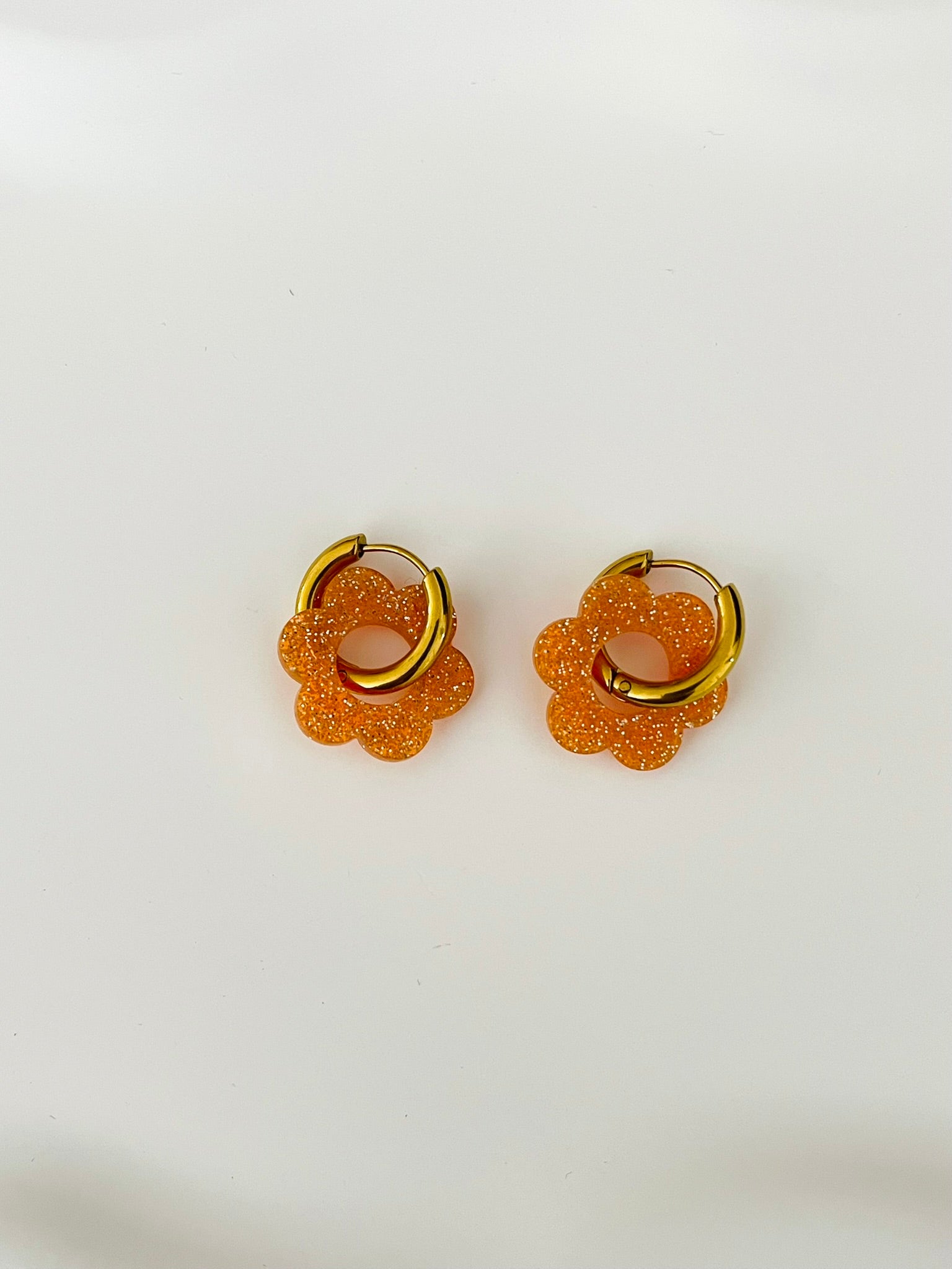 Boucles d'oreilles créoles adaptées pour les enfants à partir de 6 ans.
Créoles en acier inoxydable doré de 15mm.
Petites fleurs orange pailleté en acrylique.
