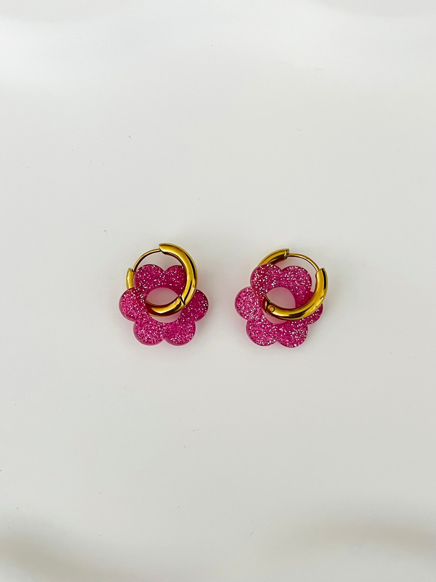 Boucles d'oreilles créoles adaptées pour les enfants à partir de 6 ans.
Créoles en acier inoxydable doré de 15mm.
Petites fleurs rose pailleté en acrylique.
