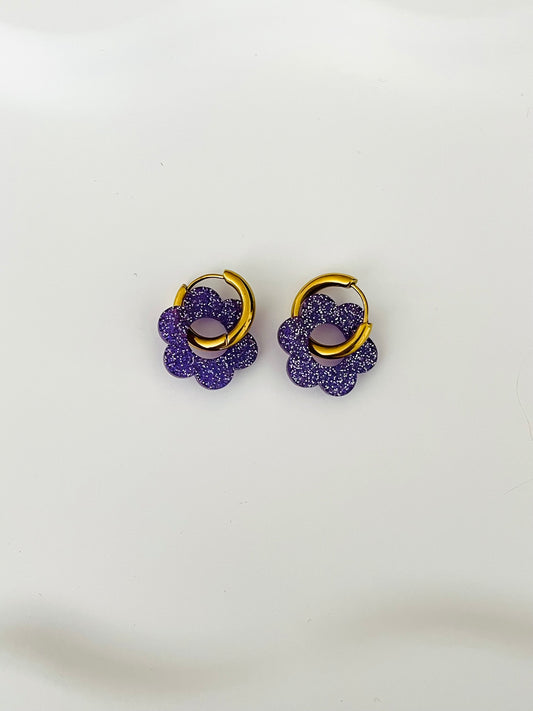 Boucles d'oreilles créoles adaptées pour les enfants à partir de 6 ans.
Créoles en acier inoxydable doré de 15mm.
Petites fleurs violet pailleté en acrylique.
