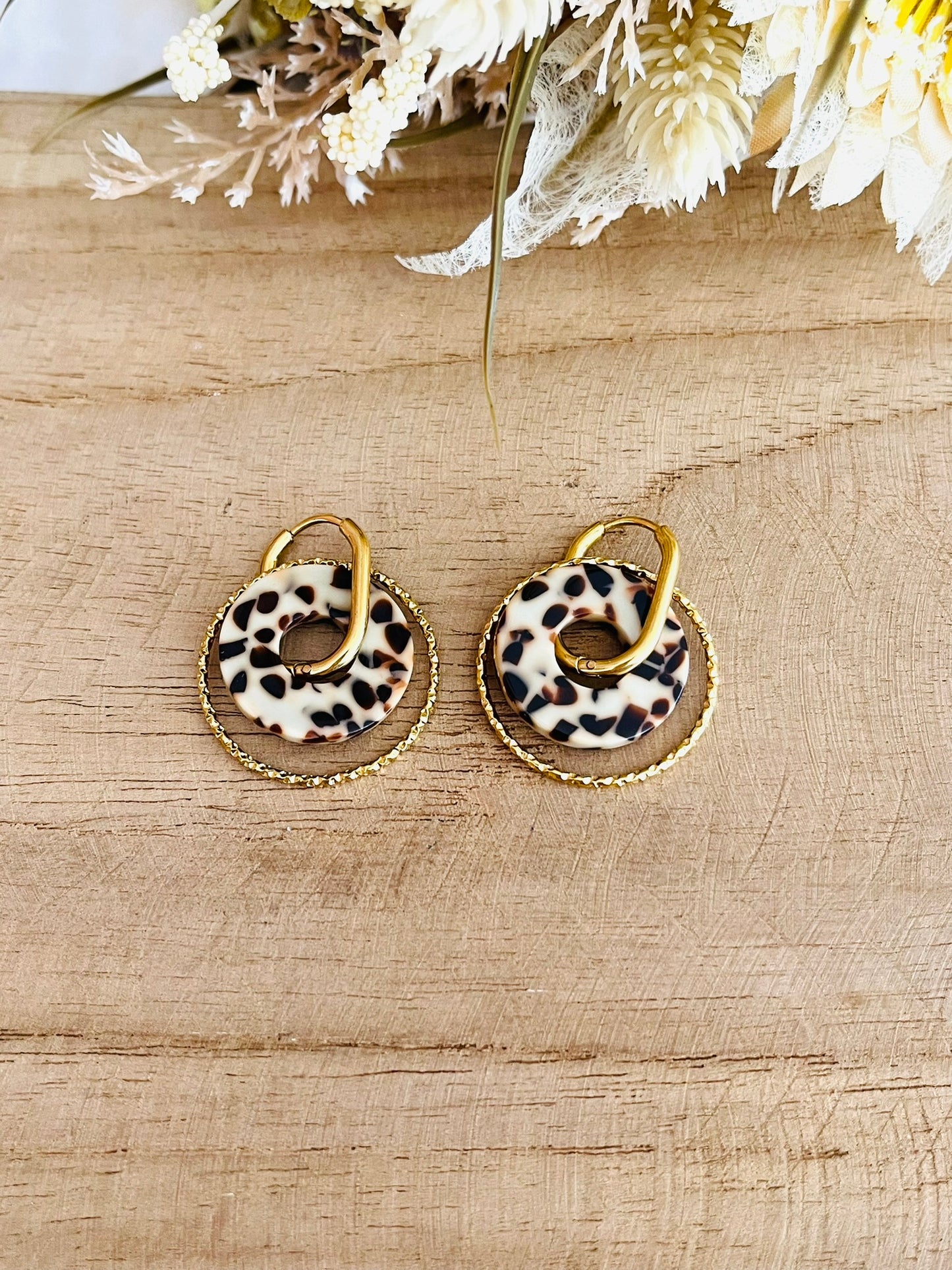 Boucles d'oreilles créoles en acier inoxydable doré.
Pendentif donut en acrylique imprimé tacheté marron et crème.
Bijou fantaisie fait main.