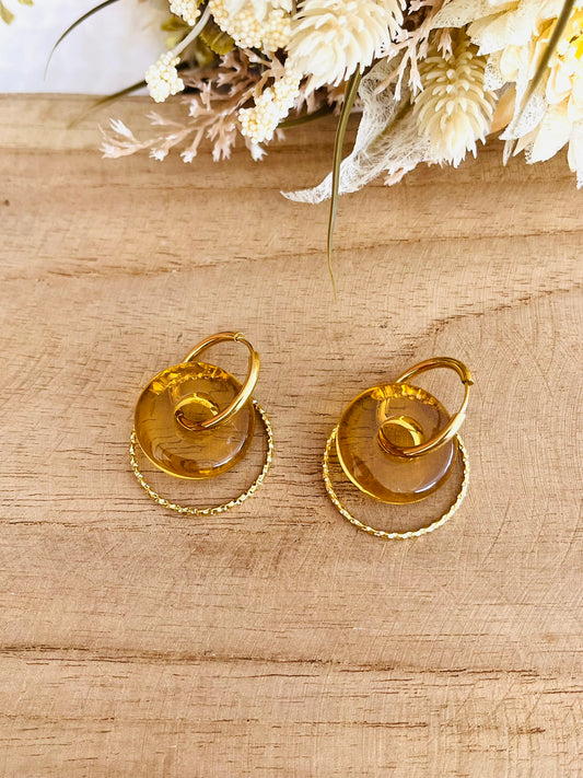Boucles d'oreilles fantaisie fait main.
Créoles rondes en acier inoxydable doré avec pendentif donut en résine jaune translucide.