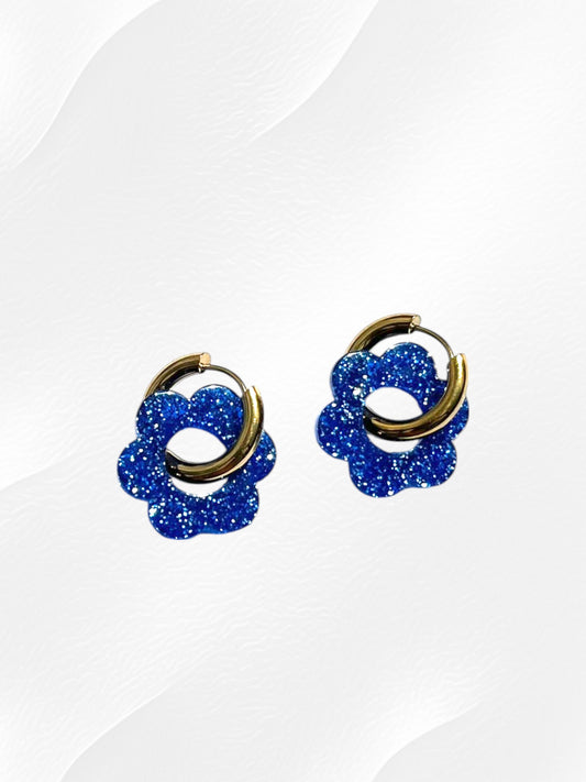 Boucles d'oreilles créoles adaptées pour les enfants à partir de 6 ans.
Créoles en acier inoxydable doré de 15mm.
Petites fleurs bleu pailleté en acrylique.