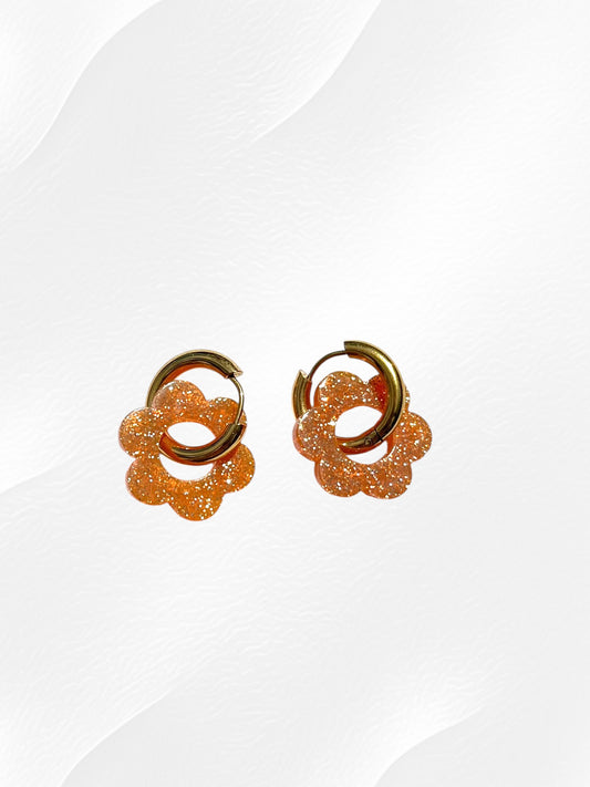Boucles d'oreilles créoles adaptées pour les enfants à partir de 6 ans.
Créoles en acier inoxydable doré de 15mm.
Petites fleurs orange pailleté en acrylique.