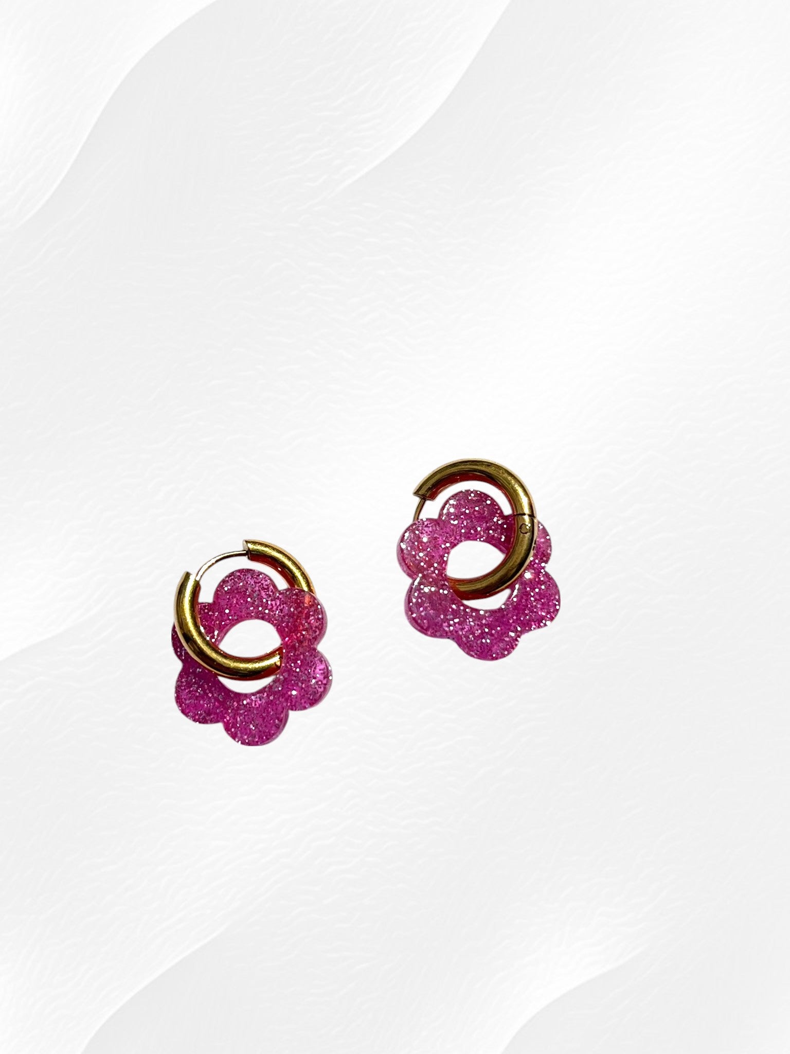 Boucles d'oreilles créoles adaptées pour les enfants à partir de 6 ans.
Créoles en acier inoxydable doré de 15mm.
Petites fleurs rose pailleté en acrylique.