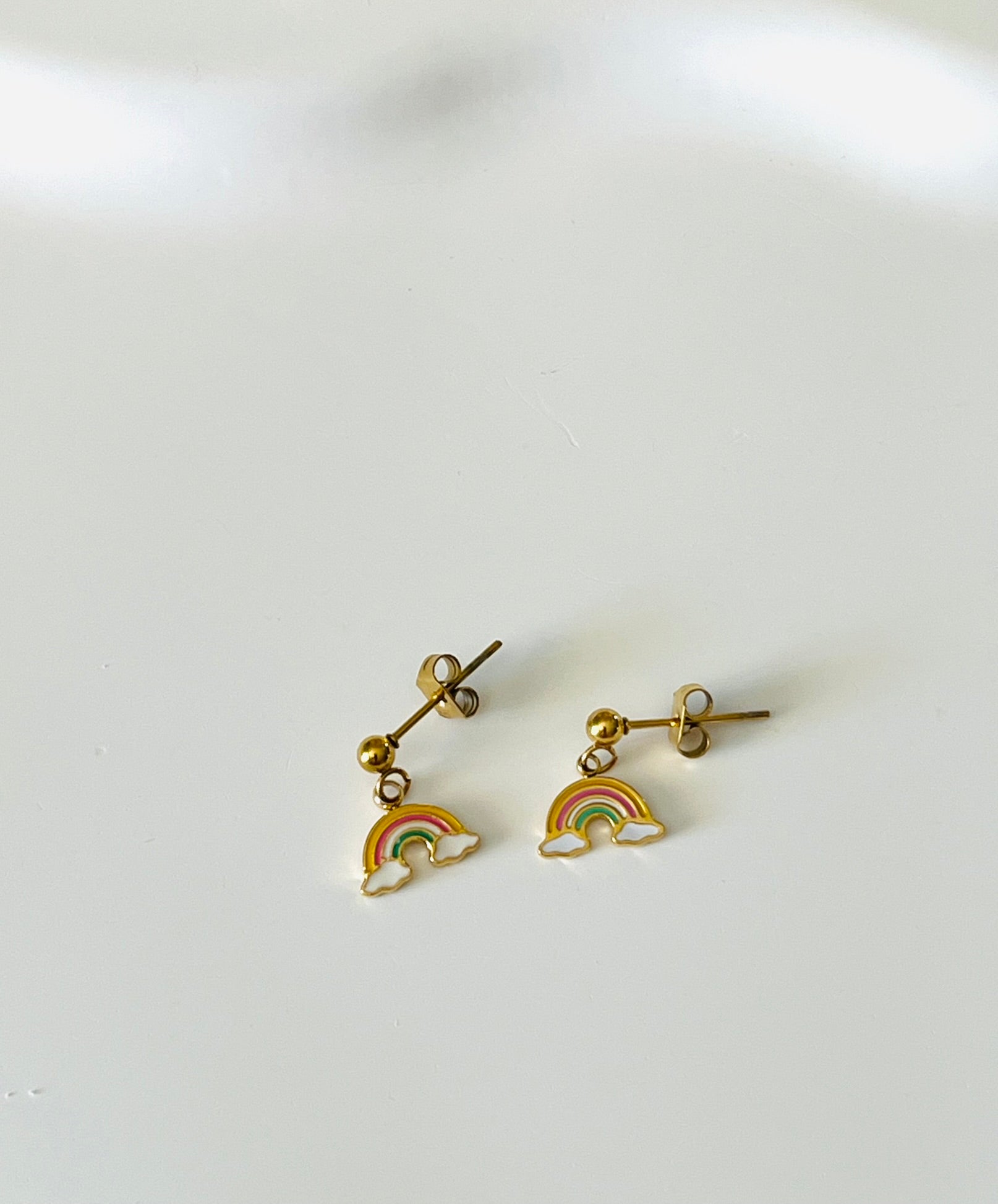Boucles d'oreilles à clous adaptées pour les enfants à partir de 6 ans.
Clous d'oreilles en acier inoxydable doré.
Pendentif arc en ciel en acier inox doré et résine epoxy.