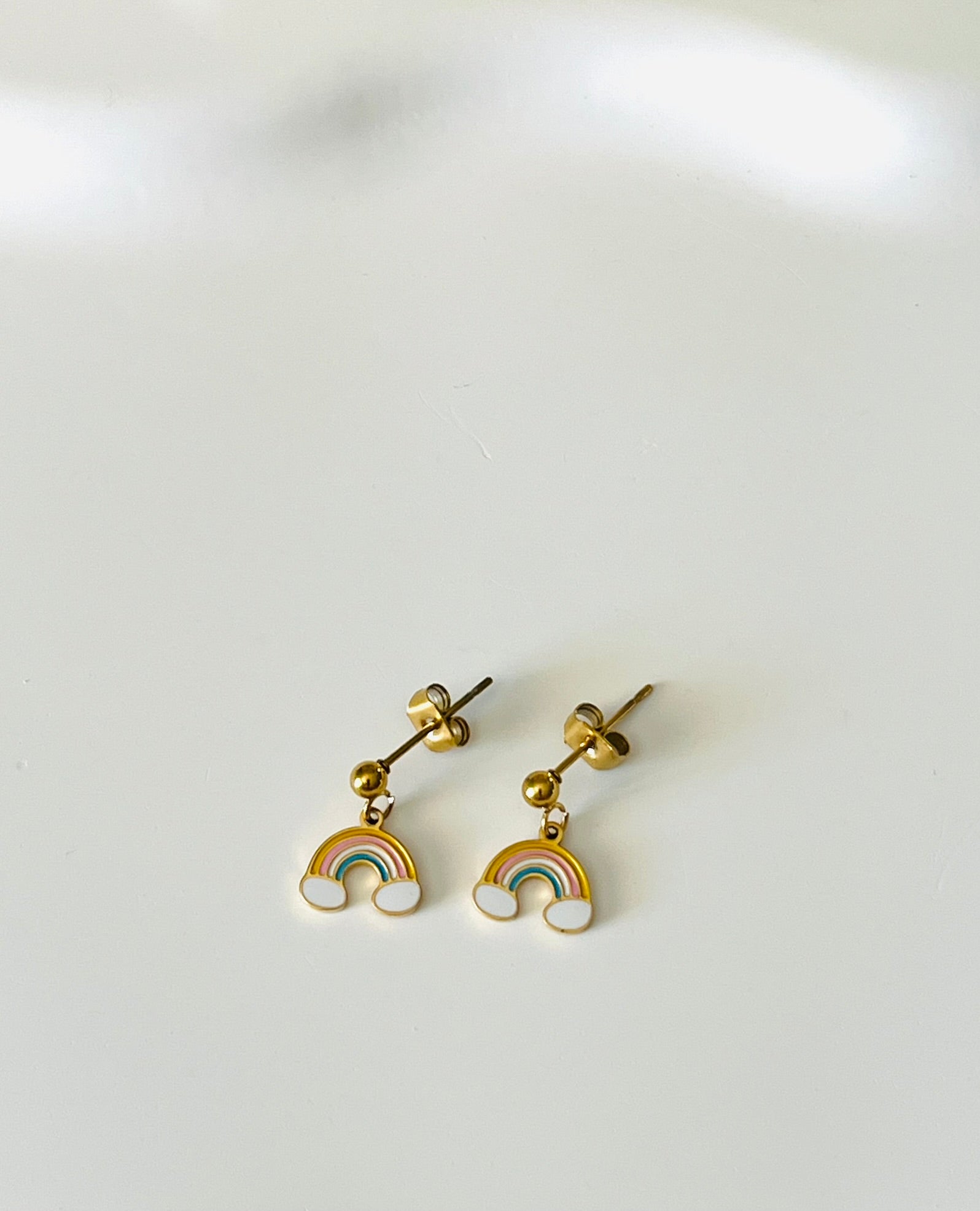 Boucles d'oreilles à clous adaptées pour les enfants à partir de 6 ans.
Clous d'oreilles en acier inoxydable doré.
Pendentif arc en ciel en acier inox doré et résine epoxy.