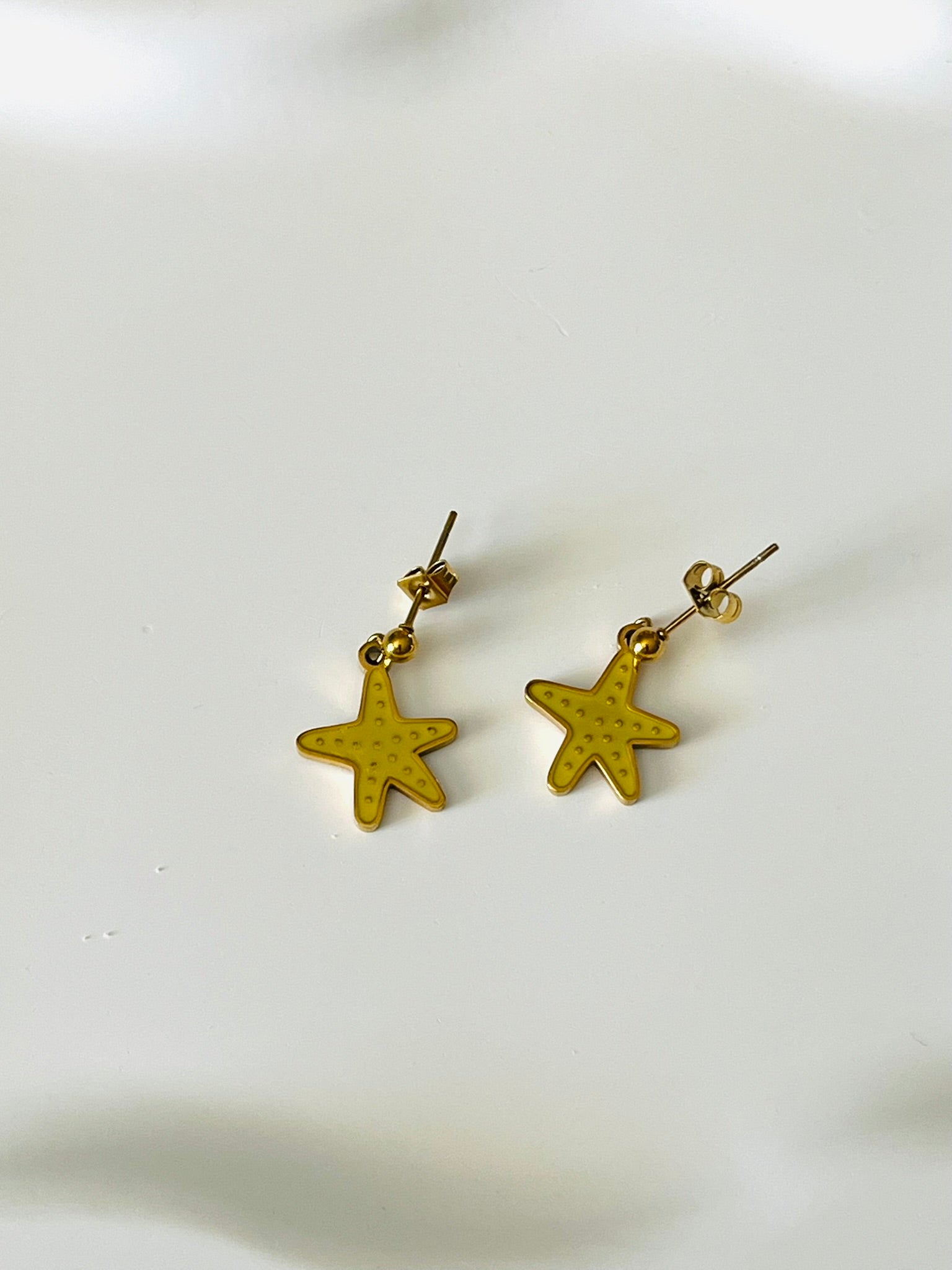 Boucles d'oreilles à clous adaptées pour les enfants à partir de 6 ans.
Clous d'oreilles en acier inoxydable doré.
Pendentif étoile de mer en acier inox doré et résine epoxy jaune.