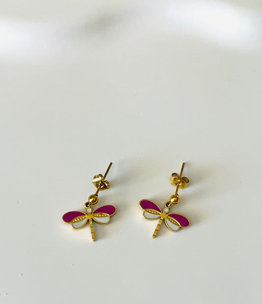 Boucles d'oreilles à clous adaptées pour les enfants à partir de 6 ans.
Clous d'oreilles en acier inoxydable doré.
Pendentif libellule en acier inox doré et résine epoxy violet et blanc.