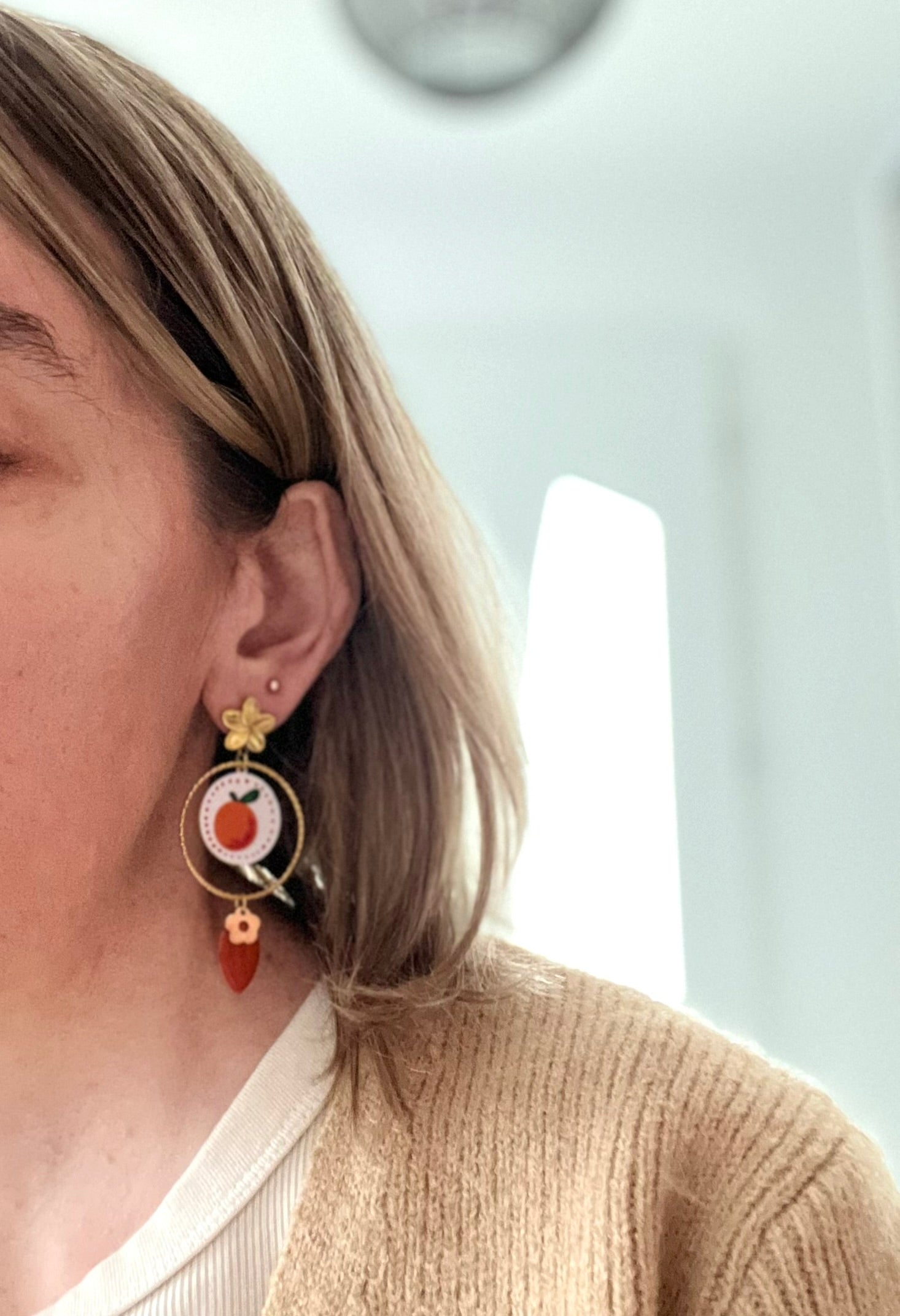 Boucles d'oreilles fantaisie fait main en acier inoxydable doré.
Clous d'oreilles fleur, anneaux ciselés de 30mm, pendentifs ronds imprimé fruit orange sur fond blanc, sequin navette émaillé orange, pampilles fleurs.

Bijou fantaisie fait main.