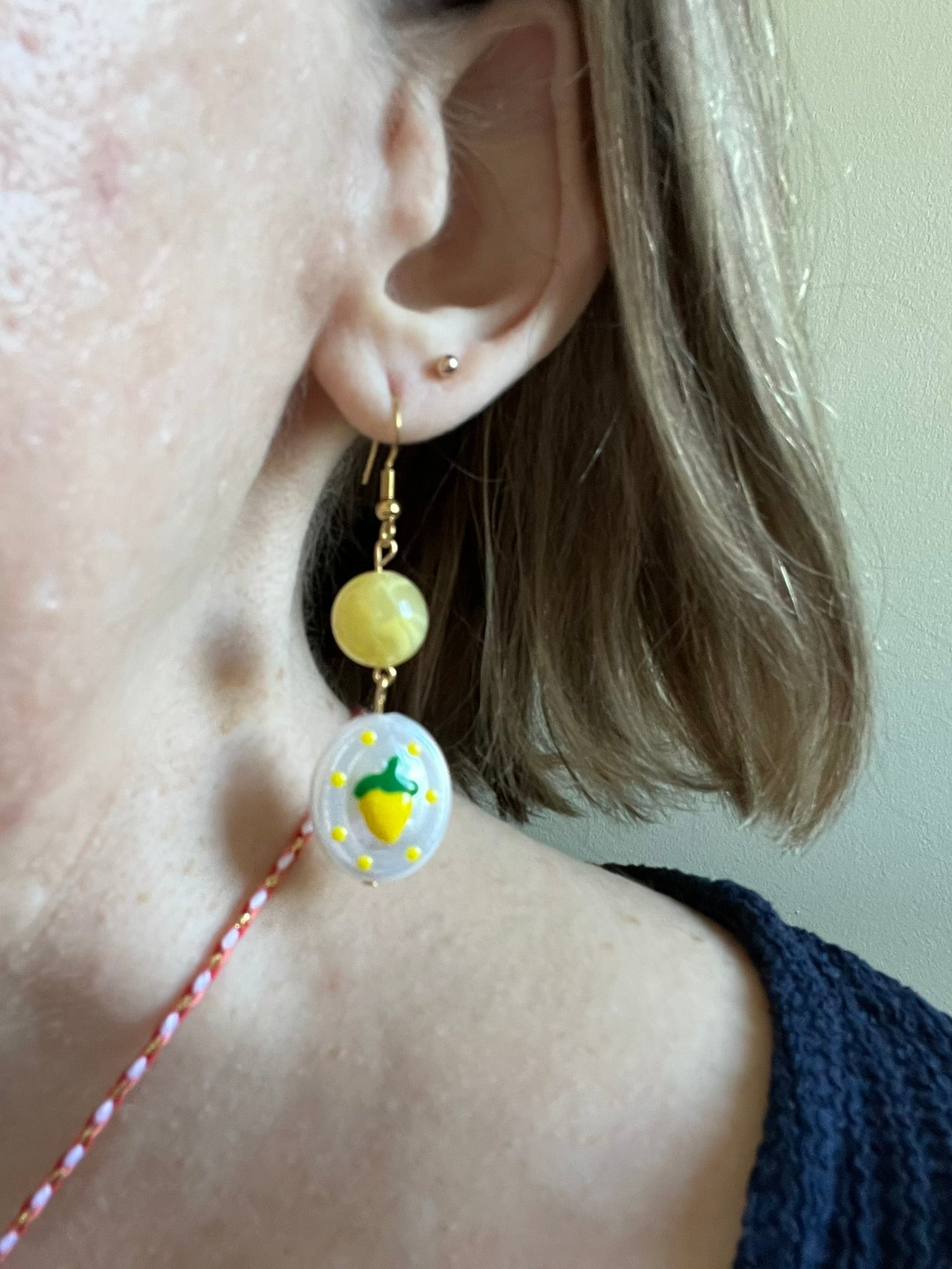 Boucles d'oreilles fantaisie fait main.
Crochets en acier inox doré. Perle ronde en acrylique jaune. Perle ovale en acrylique blanc nacré avec motif citron.
Bijou fantaisie fait main.