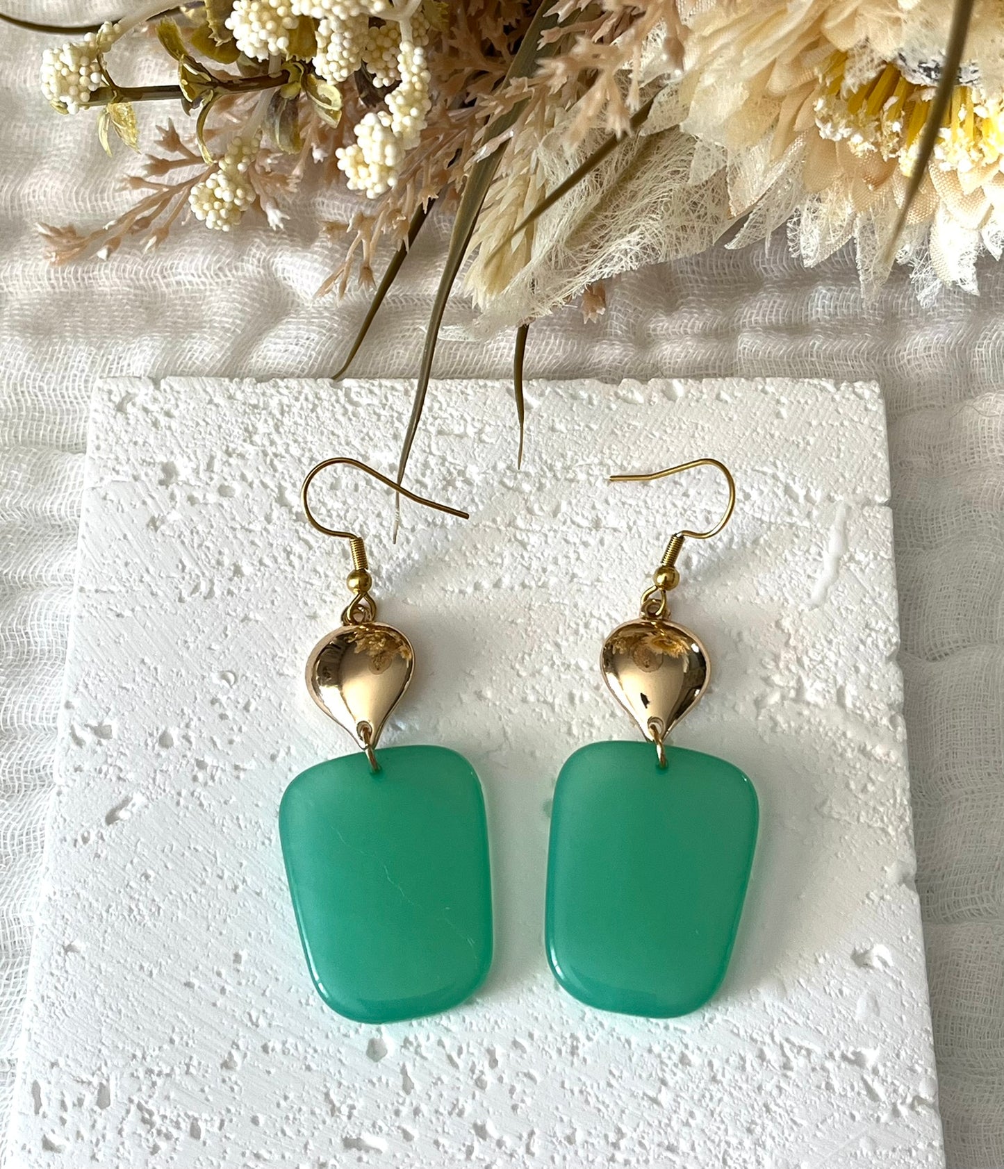 Boucles d'oreilles fantaisie fait main.
Crochets en acier inox doré.
Connecteurs goutte dorés.
Pendentifs trapèze en résine vert.
Bijou fantaisie fait main.