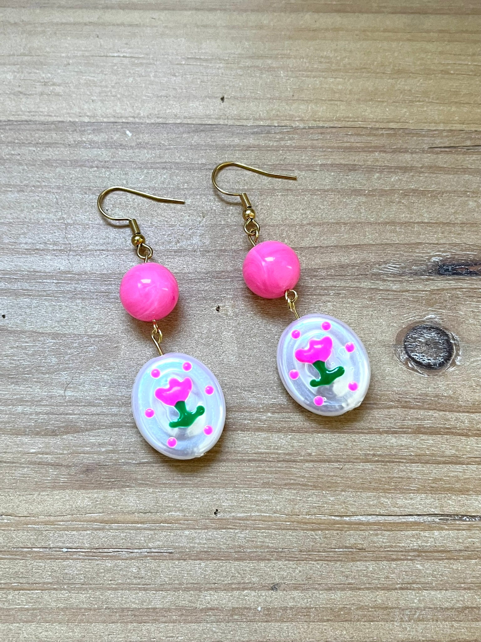 Boucles d'oreilles fantaisie fait main.
Crochets en acier inox doré.
Perles rondes en acrylique rose vif.
Perles ovale en acrylique blanc nacré avec motif tulipe.
Bijou fantaisie fait main.