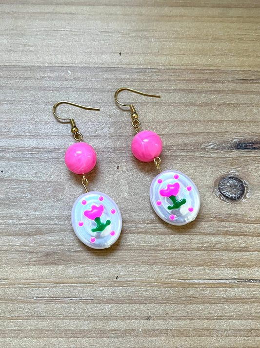 Boucles d'oreilles fantaisie fait main.
Crochets en acier inox doré.
Perles rondes en acrylique rose vif.
Perles ovale en acrylique blanc nacré avec motif tulipe.
Bijou fantaisie fait main.