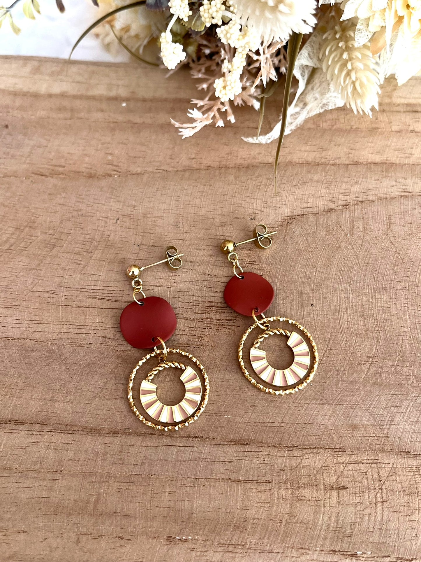 Boucles d'oreilles fantaisie fait main.
Clous d'oreilles en acier doré, sequin ondulé marron, pendentif design en acier doré et émail rose et blanc.
Bijou artisanal fait main.