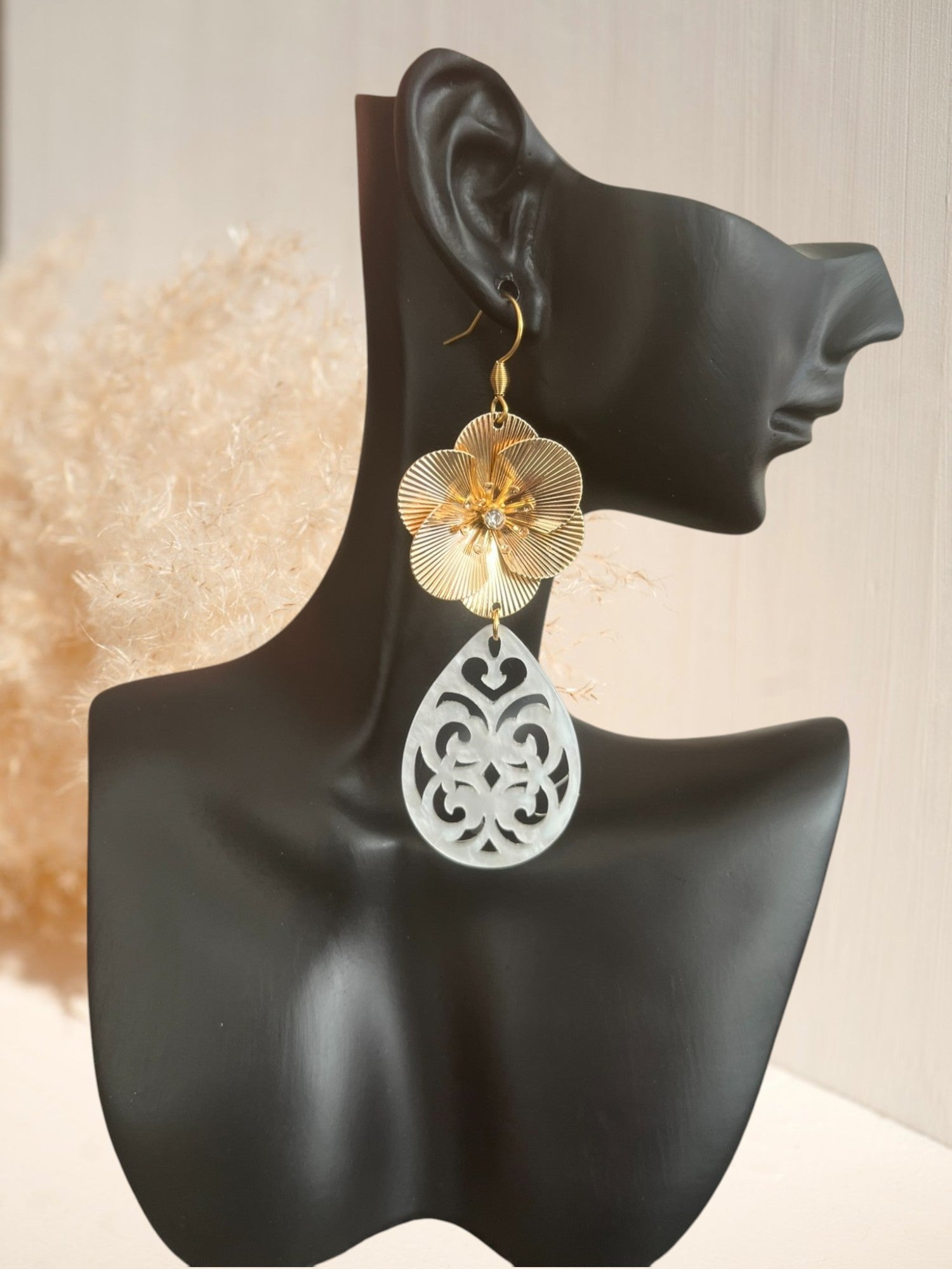 Boucles d'oreilles fantaisie style baroque. Grosse fleur dorée et pendentif goutte ajouré en acrylique blanc.
Bijou fantaisie fait main.