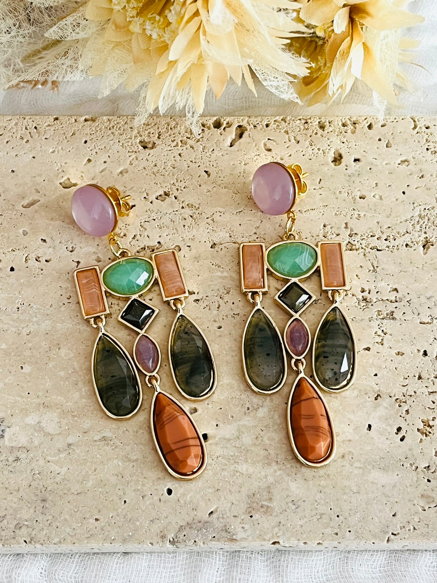 Boucles d'oreilles fantaisie fait main.
Clous d'oreilles en laiton doré à l'or fin avec un cabochon en résine de couleur lilas.
Grands pendentifs chandeliers sertis de cabochons en résine vert, orange, marron.
Bijou fantaisie fait main.